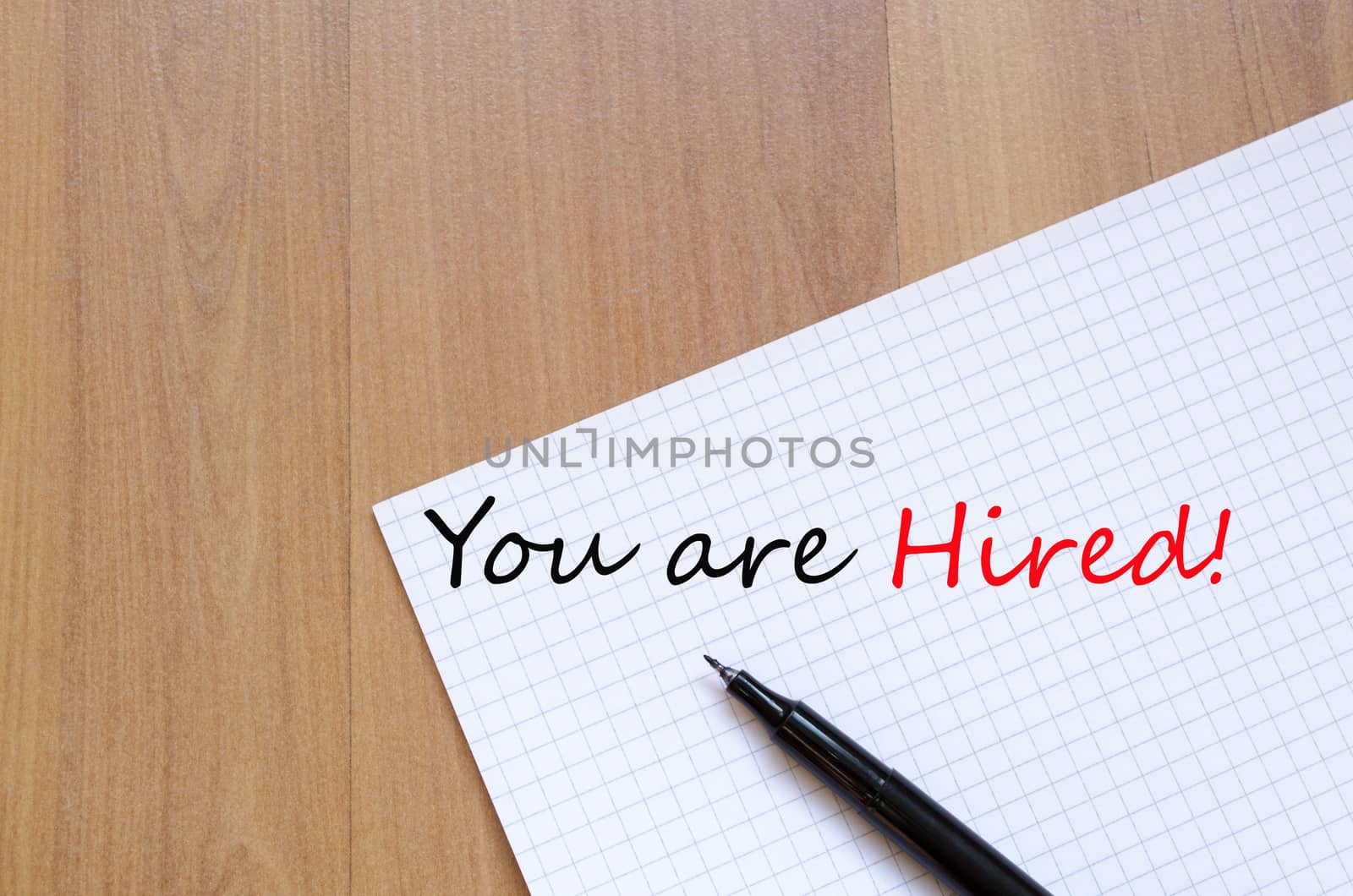 White blank notepad on office wooden table You are hired concept