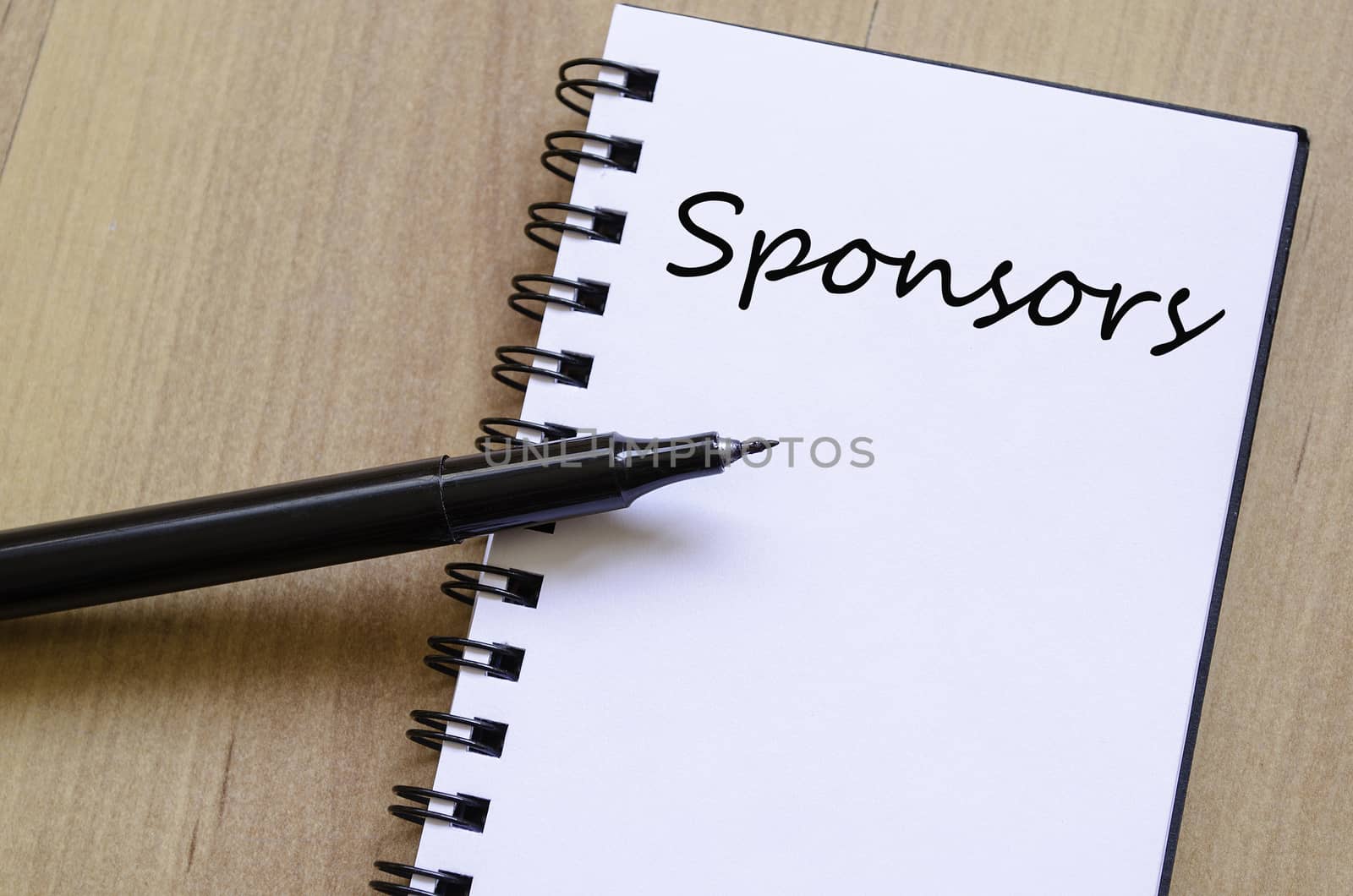 White notepad and ink pen on the wooden desk Sponsors Concept