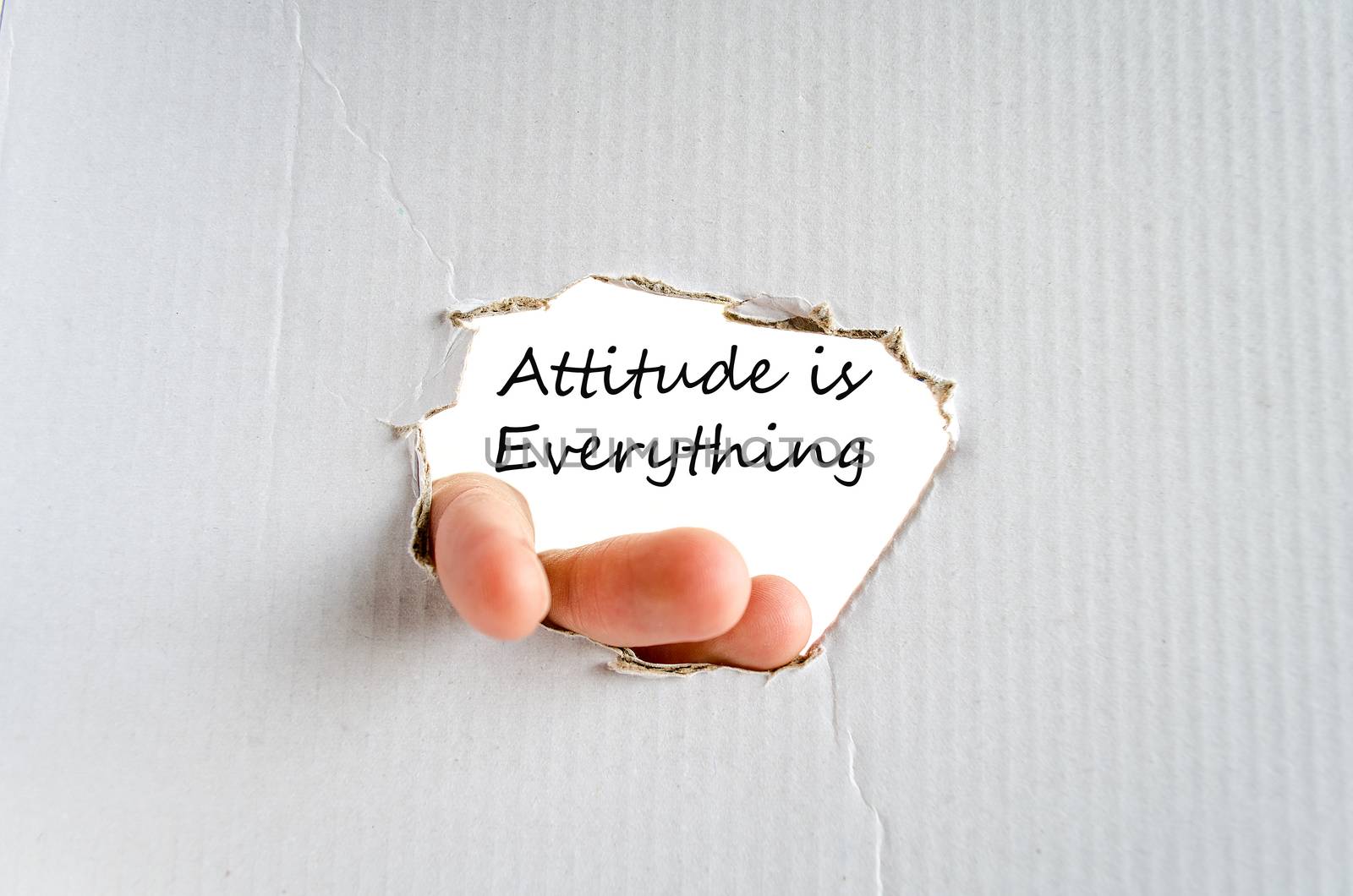 Hand and text on the cardboard background Attitude is Everything Concept