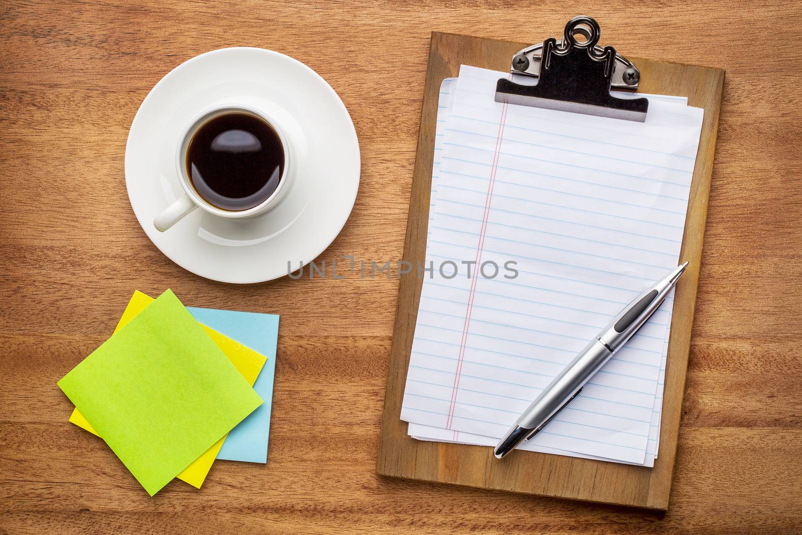 desktop concept - clipboard with blank paper and pen, sticky notes and coffee