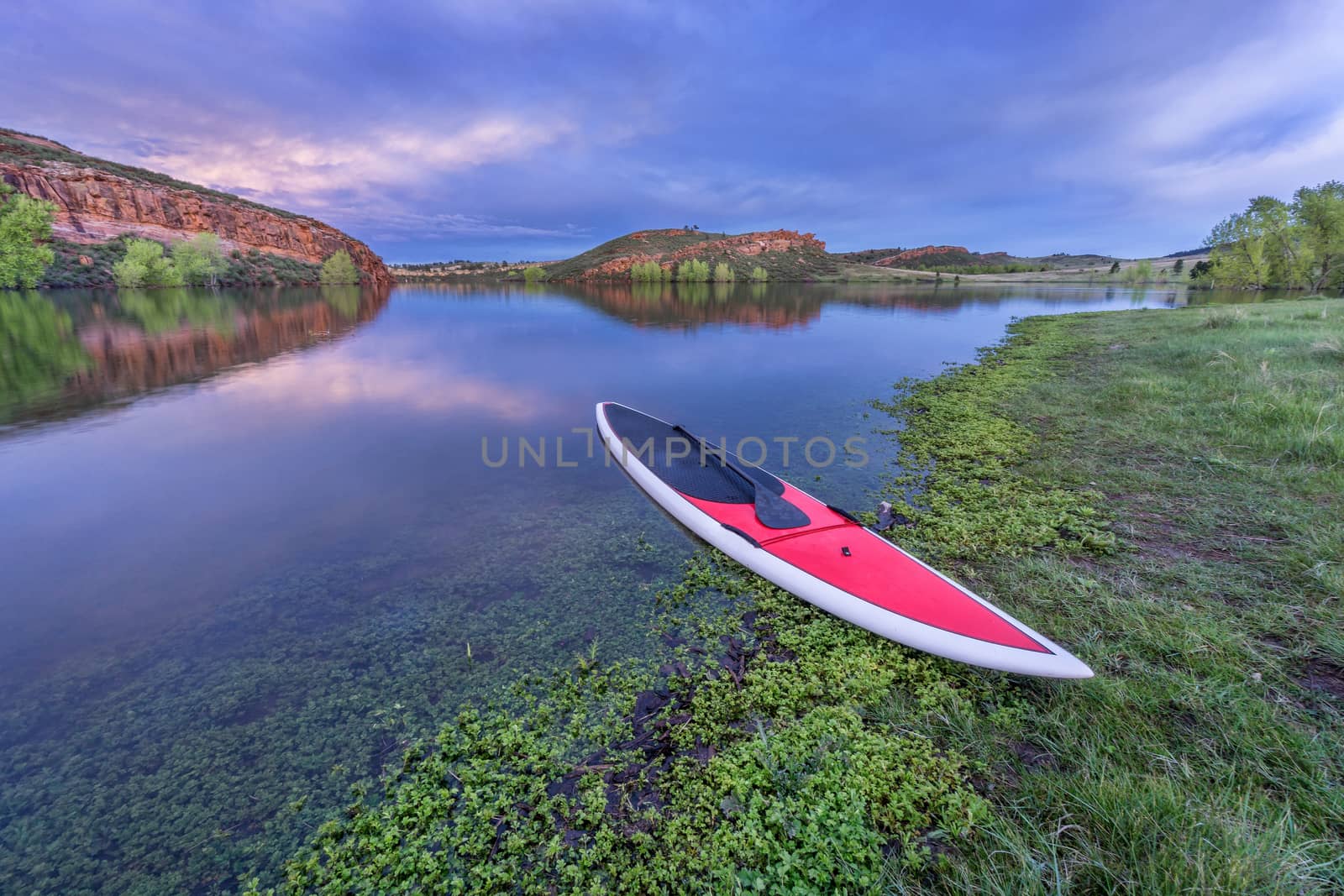 dusk over lake with paddleboard by PixelsAway