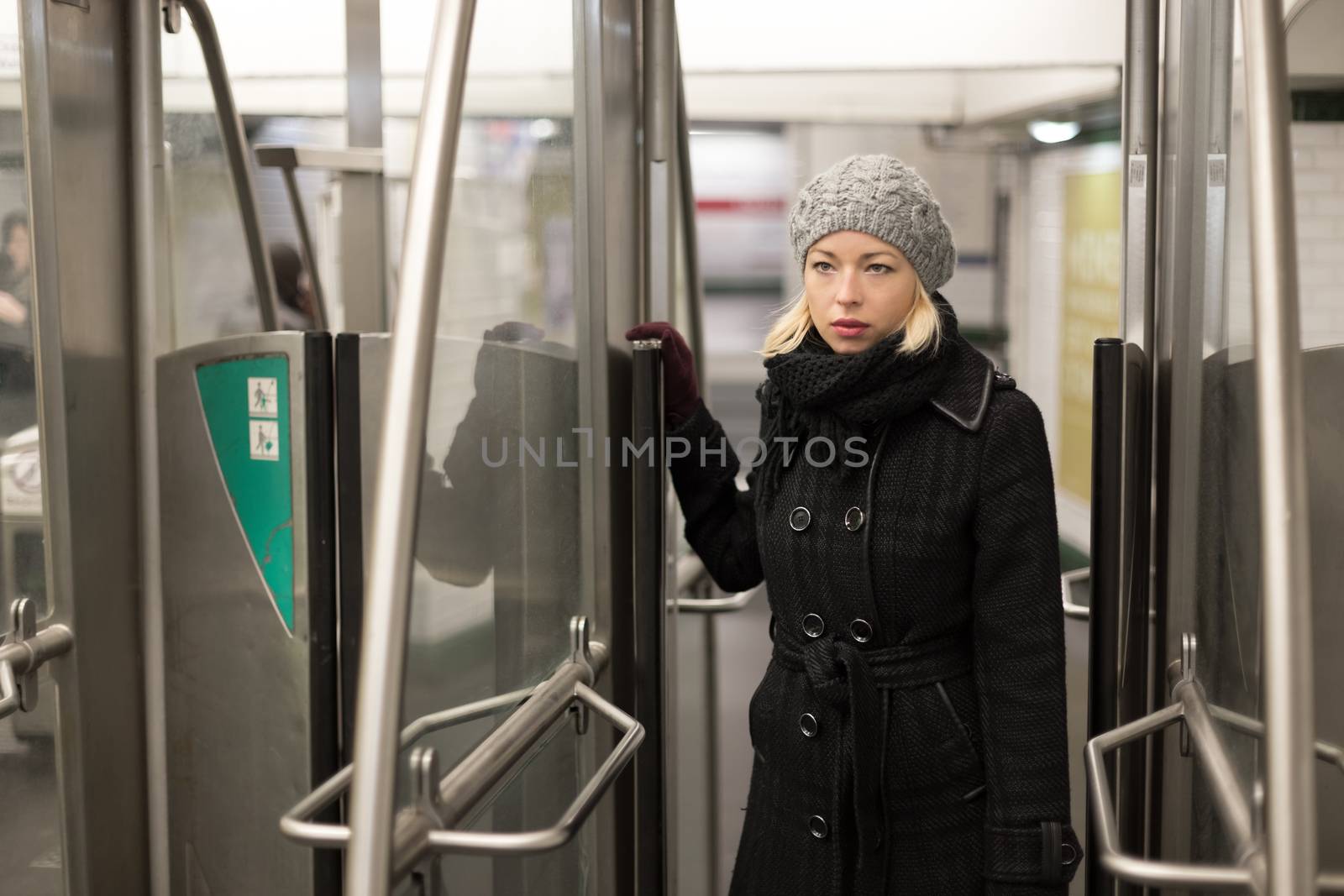 Beautiful blonde caucasian lady entering the metro station. Public transport.