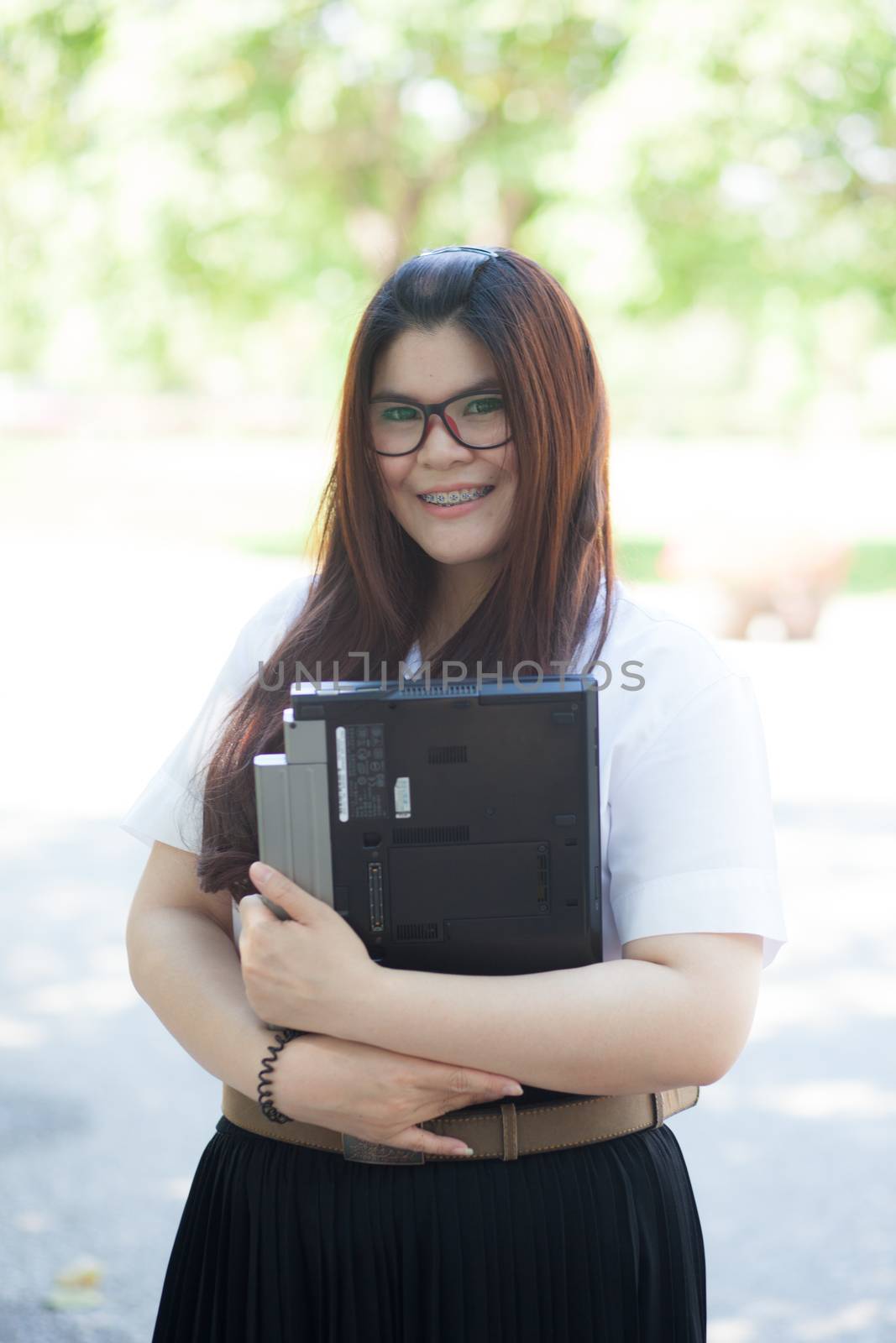 Female student holding notebook computer. Woman wearing glasses and smiling