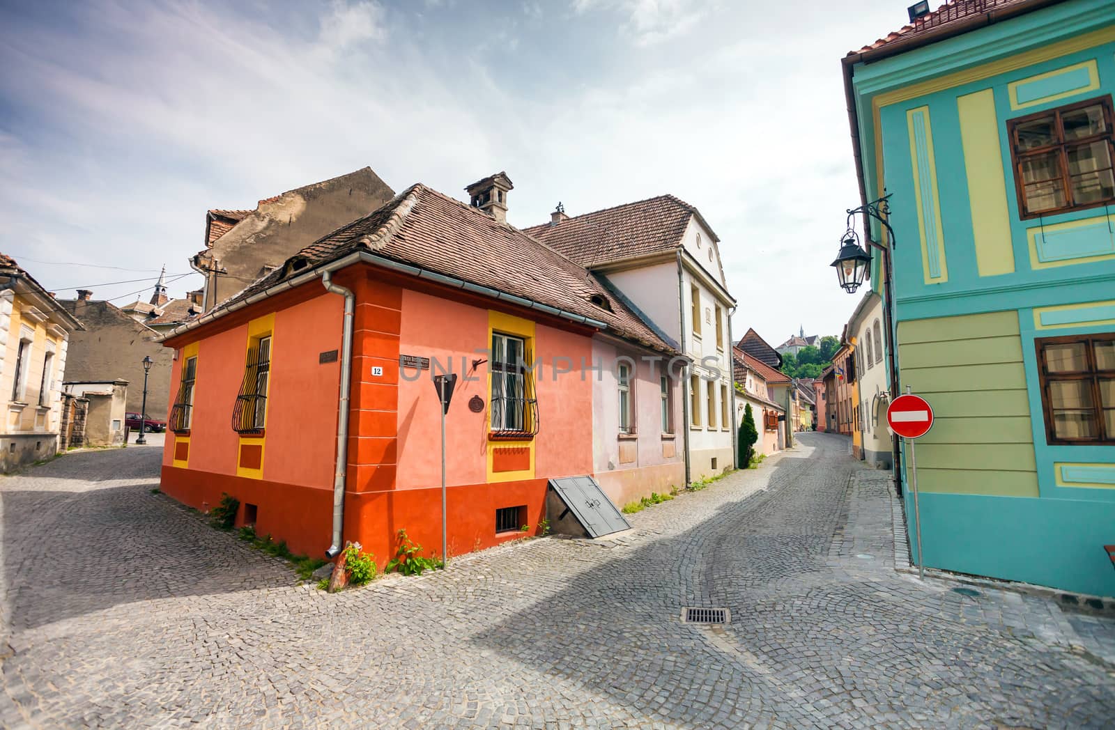 Sighisoara, Romania - June 23, 2013: Stone paved old streets with colored houses from Sighisoara fortresss, Transylvania, Romania