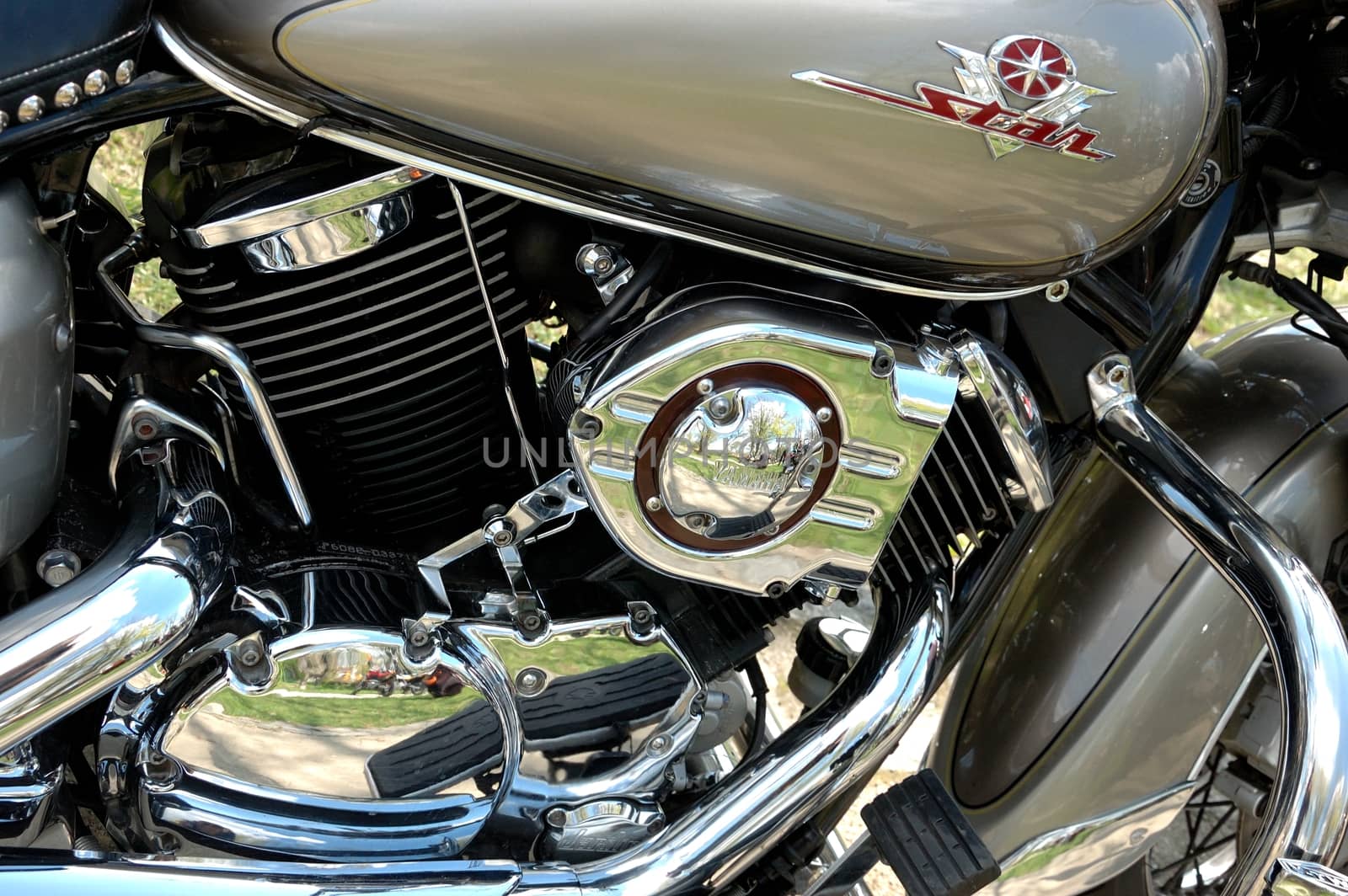 Closeup photo of motorbike engine with shiny chrome parts, different metal components.