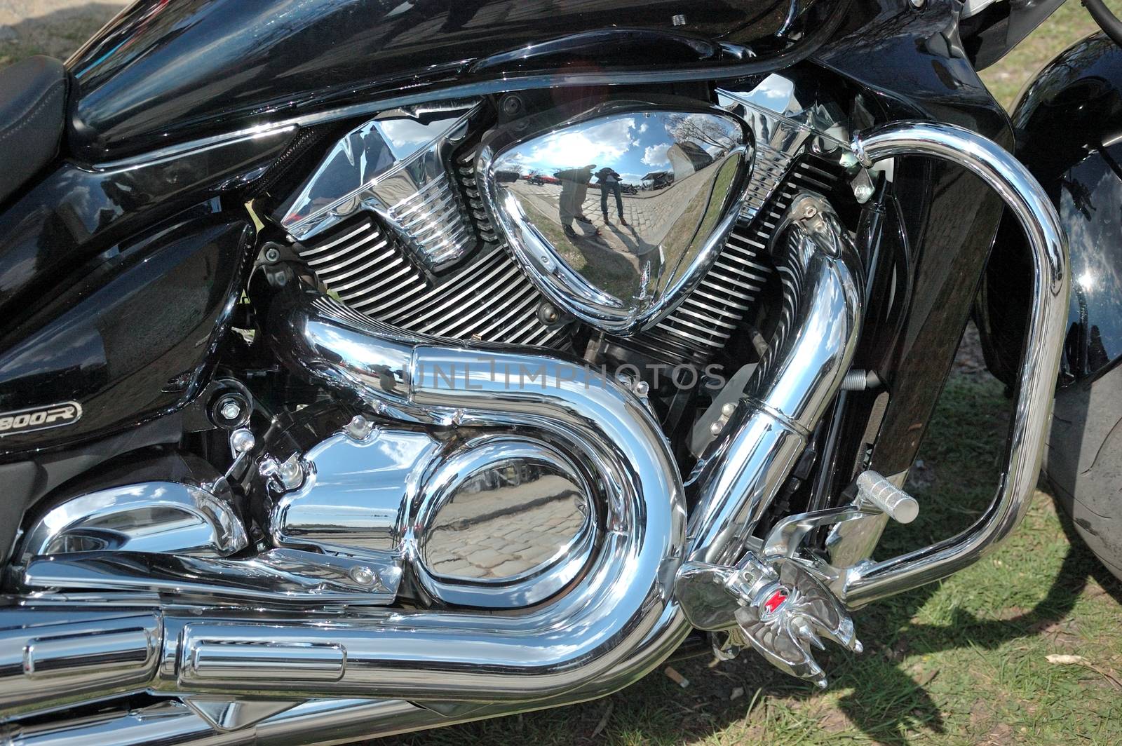 Closeup photo of motorbike engine with shiny chrome parts, different metal components.