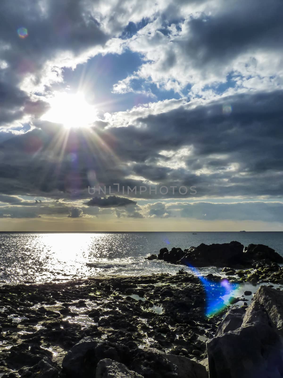 Sky with clouds over black sea rocks by ankarb