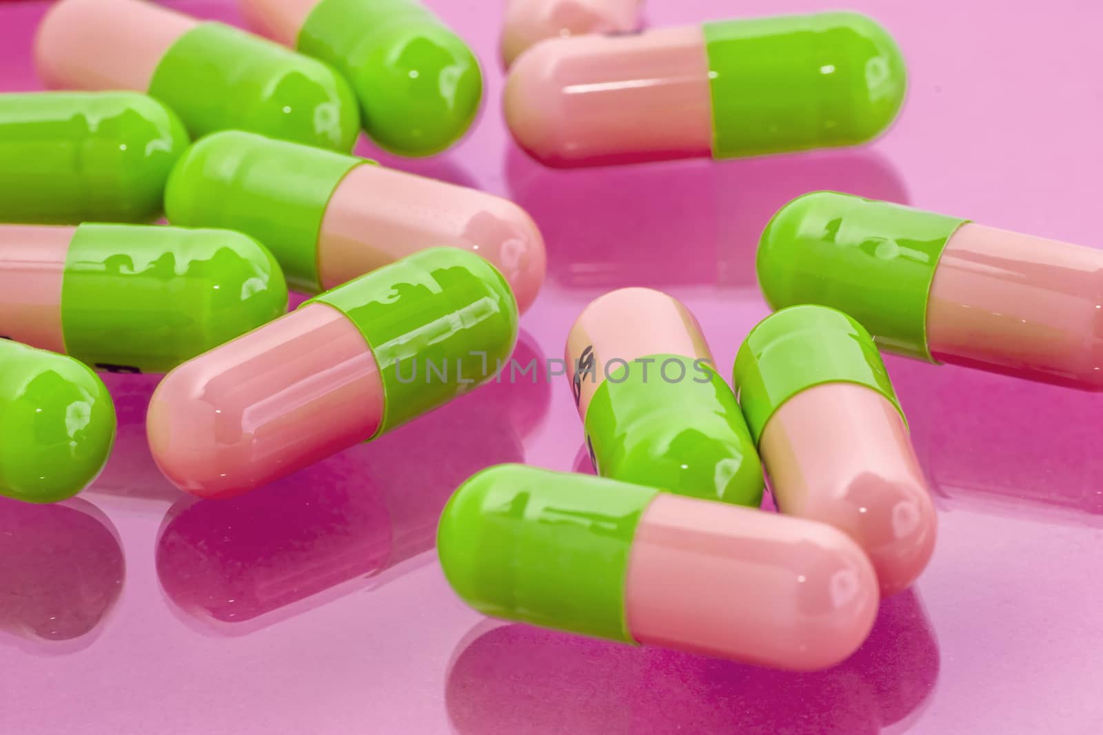 several pink-green pills spilling on the table