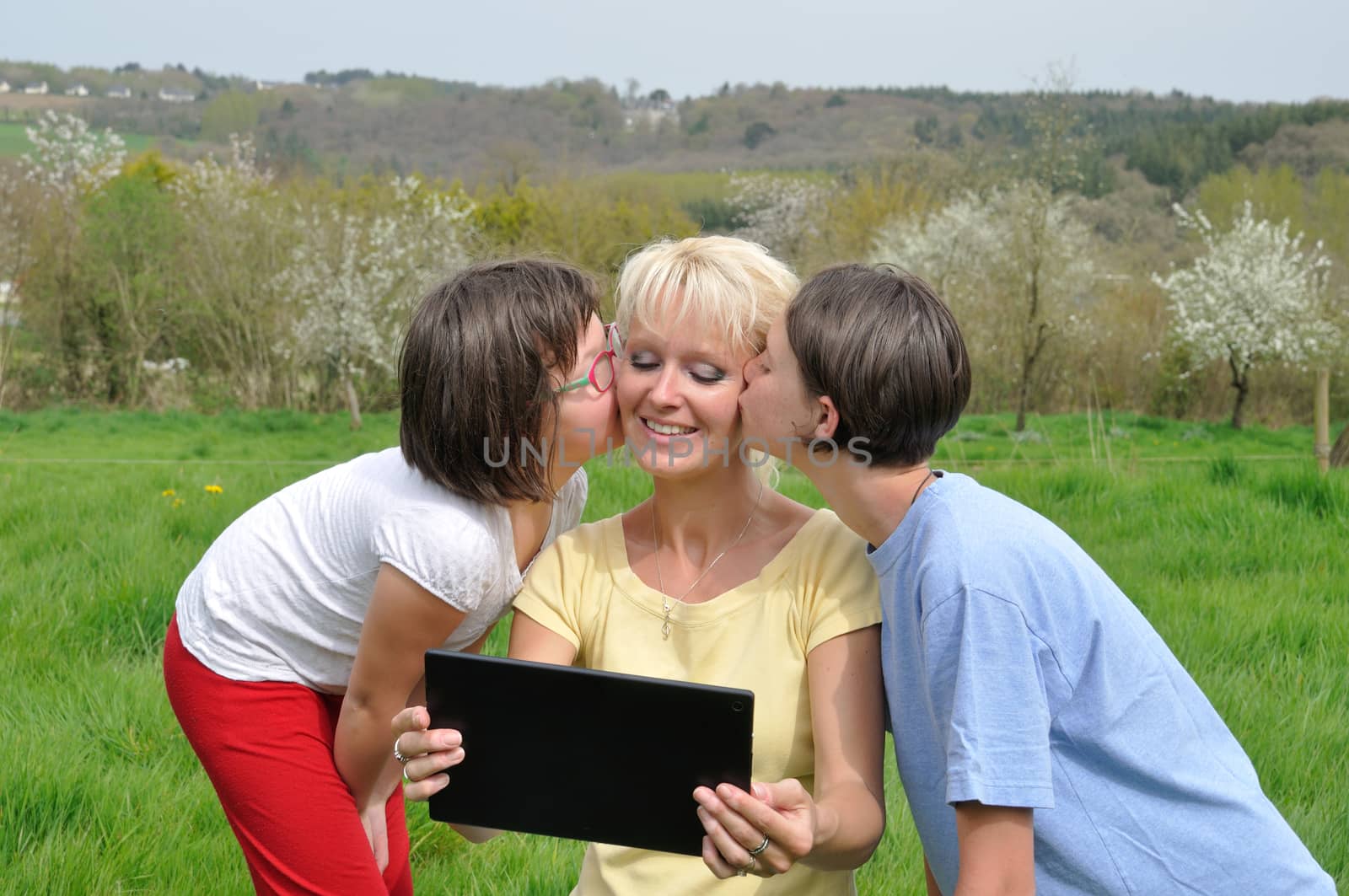 Family sitting on the lawn and using digital tablet