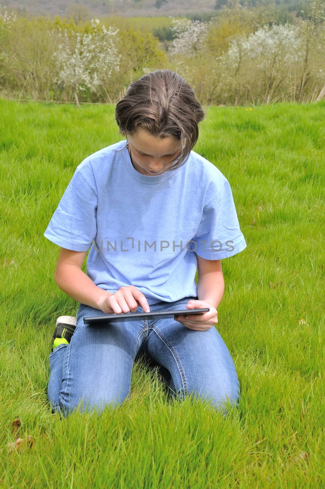 Girl sitting on the lawn and using digital tablet by BZH22
