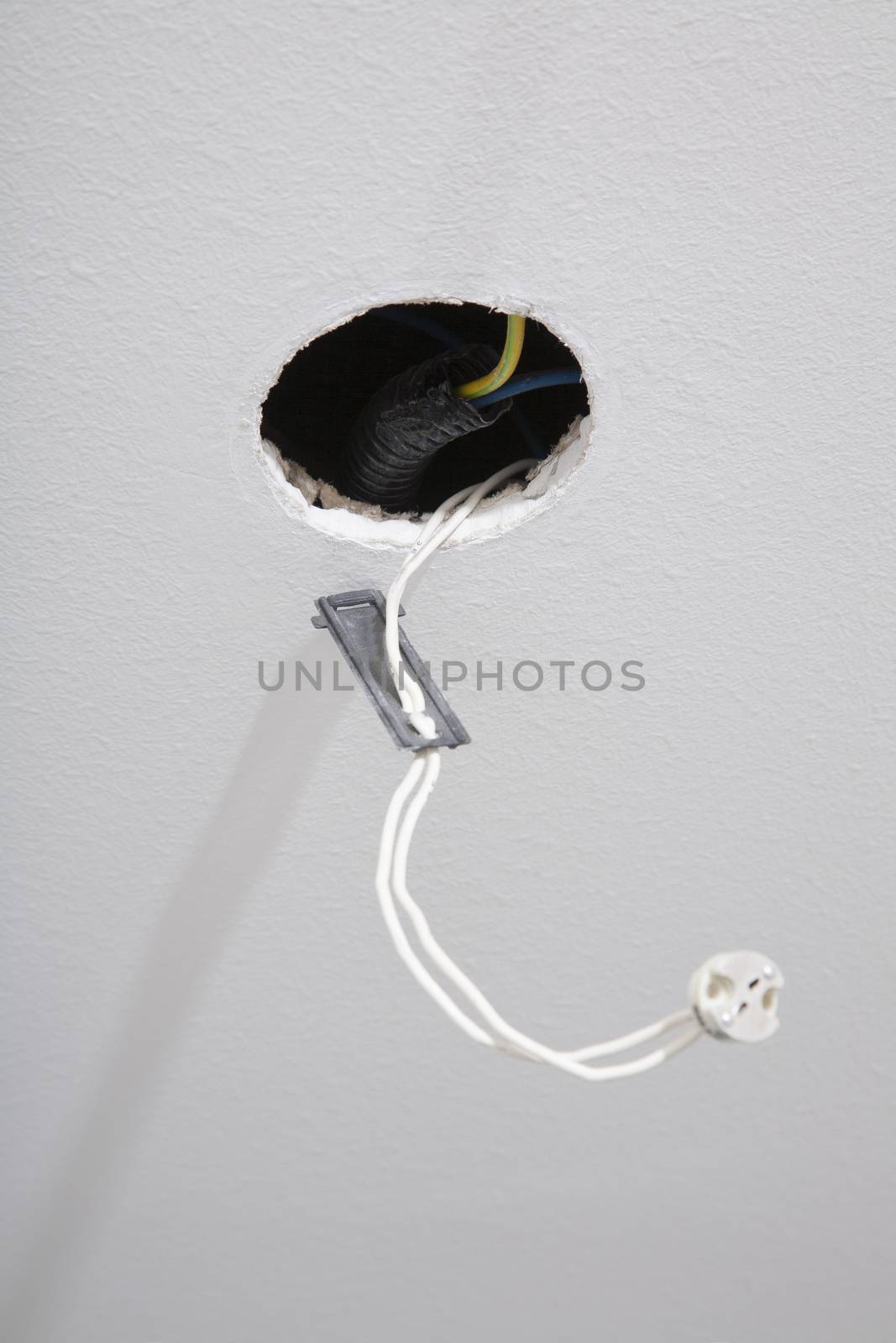 white indoor ceiling with circular hole cable ready for spotlight recessed