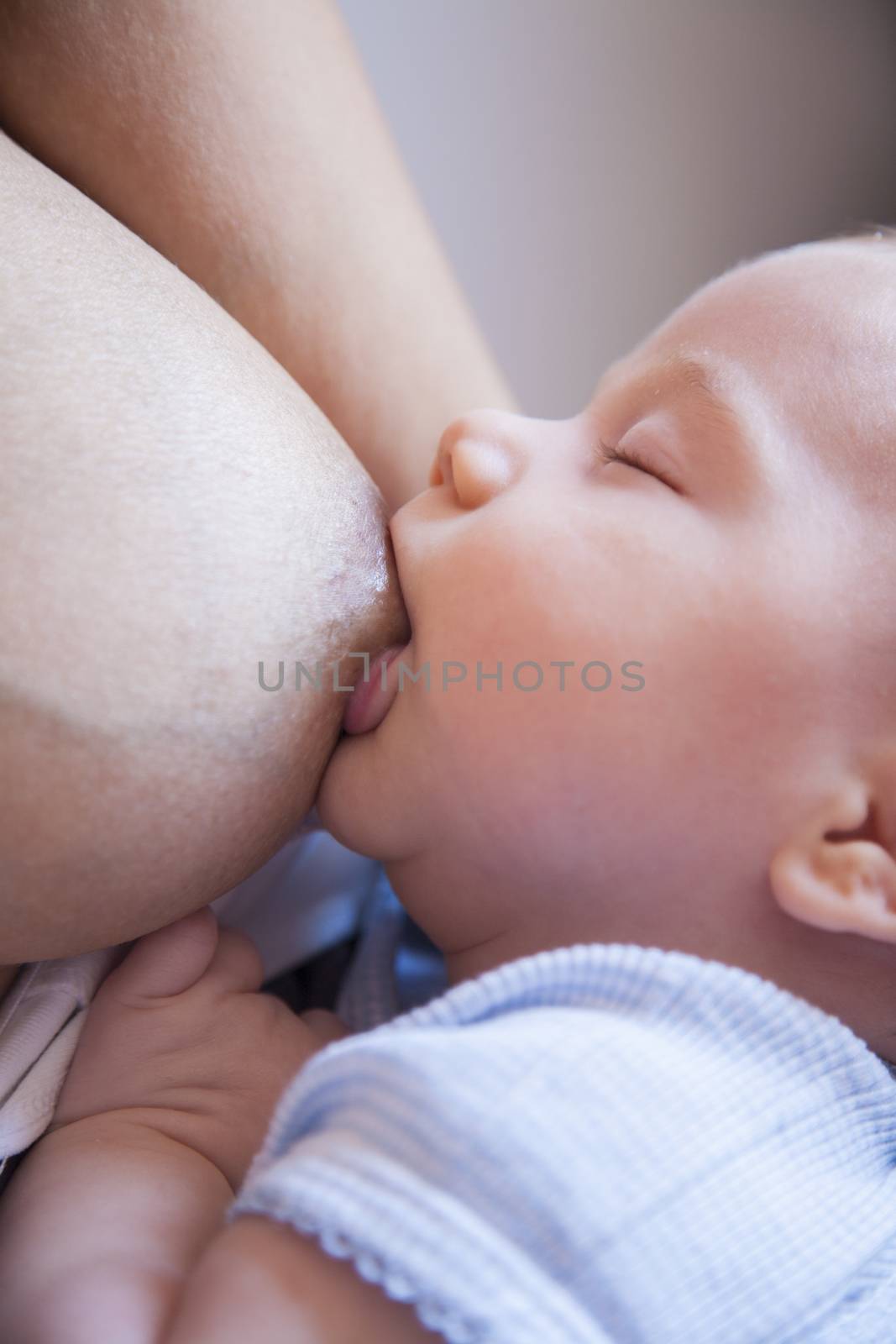 one month age tender lovely newborn baby closed eye blue shirt breastfeeding nursing mother breast