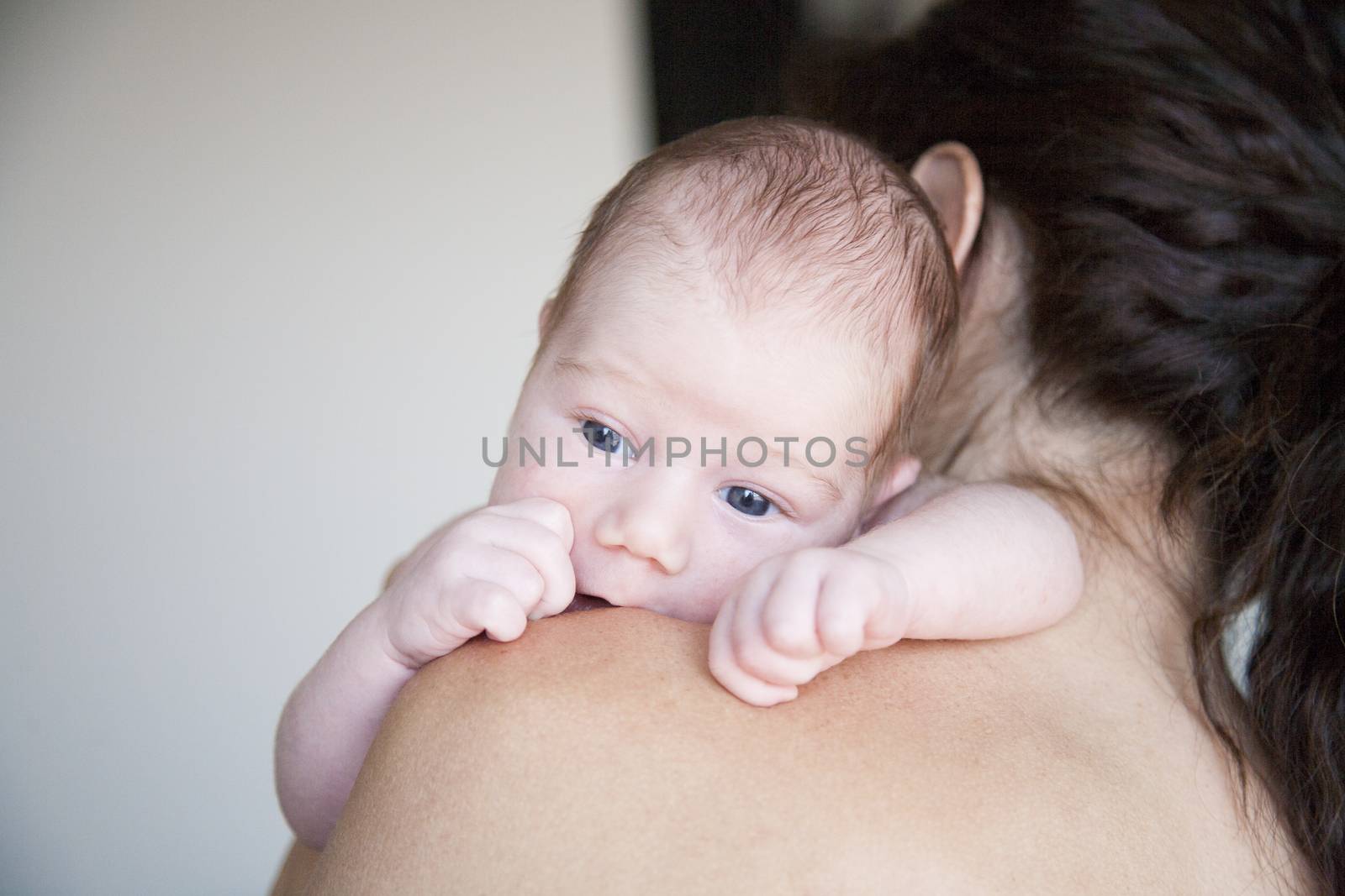 newborn baby on mother shoulder by quintanilla