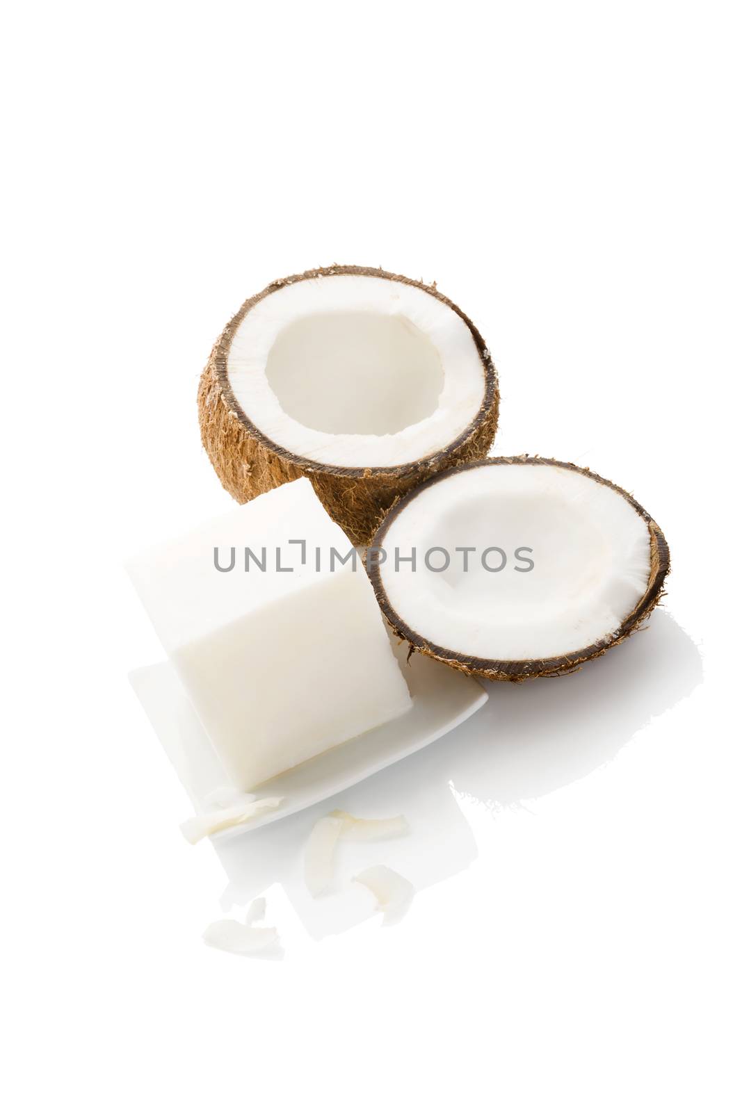 Organic hard coconut oil on plated with coconut isolated on white background. Healthy eating and cooking.