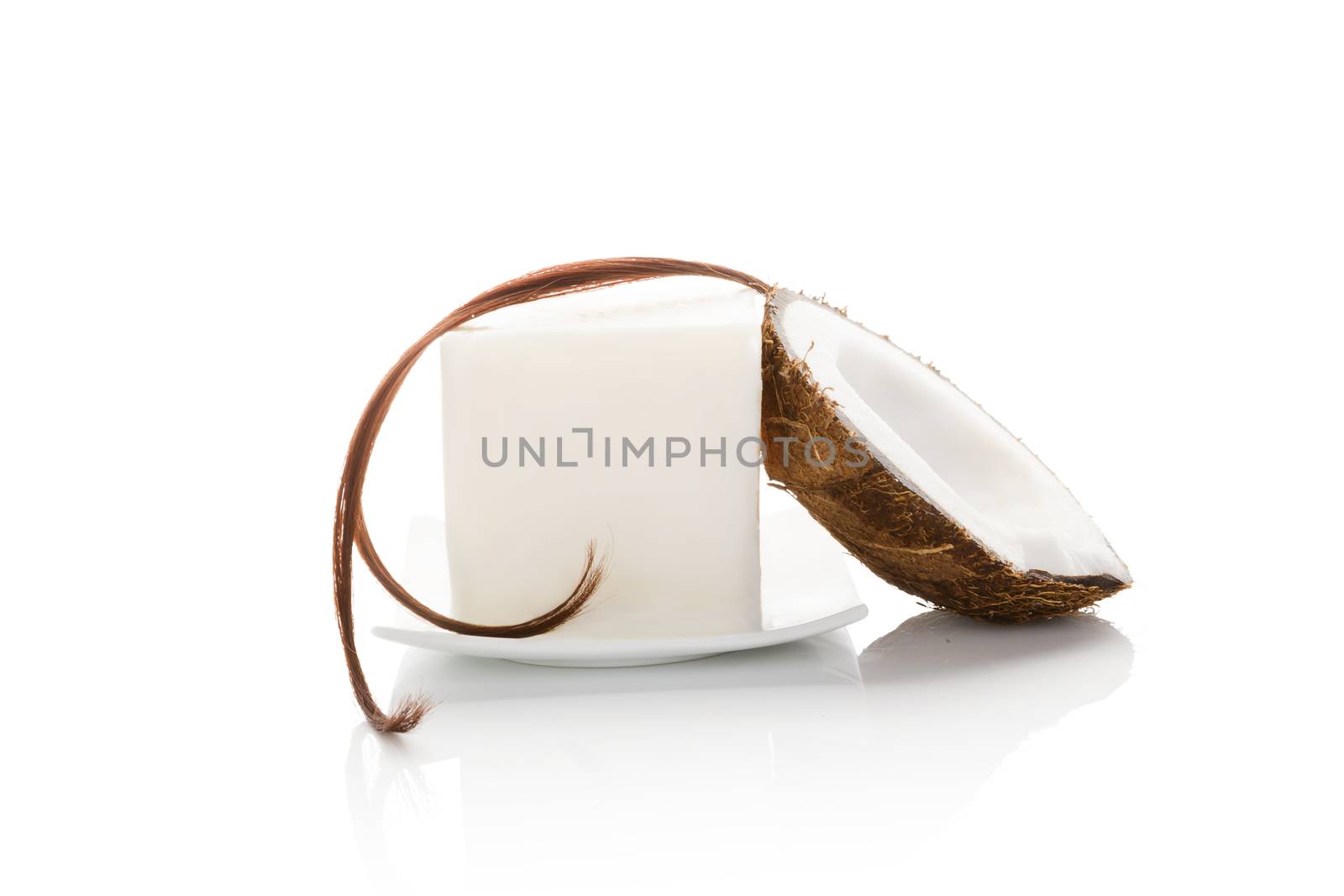 Organic hard coconut oil with a string of hair and half coconut isolated on white background. Natural organic cosmetics, body and hair care.