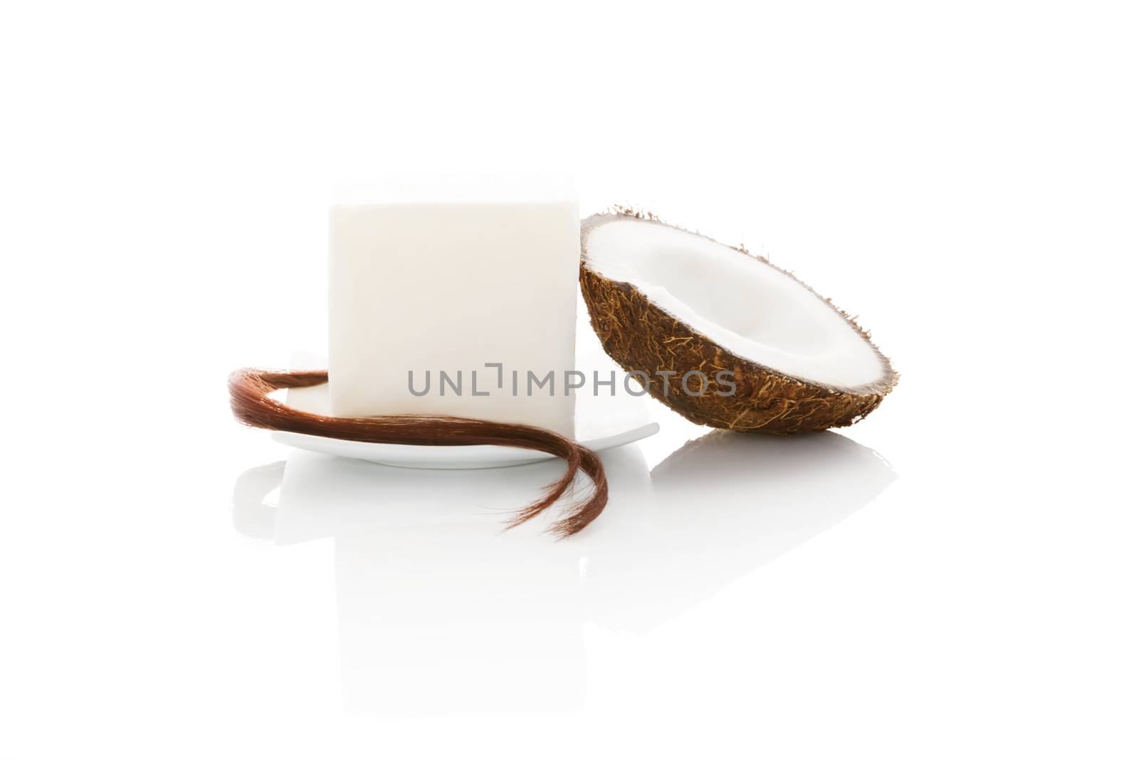 Organic hard coconut oil with a string of hair and half coconut isolated on white background. Natural organic cosmetics, body and hair care.