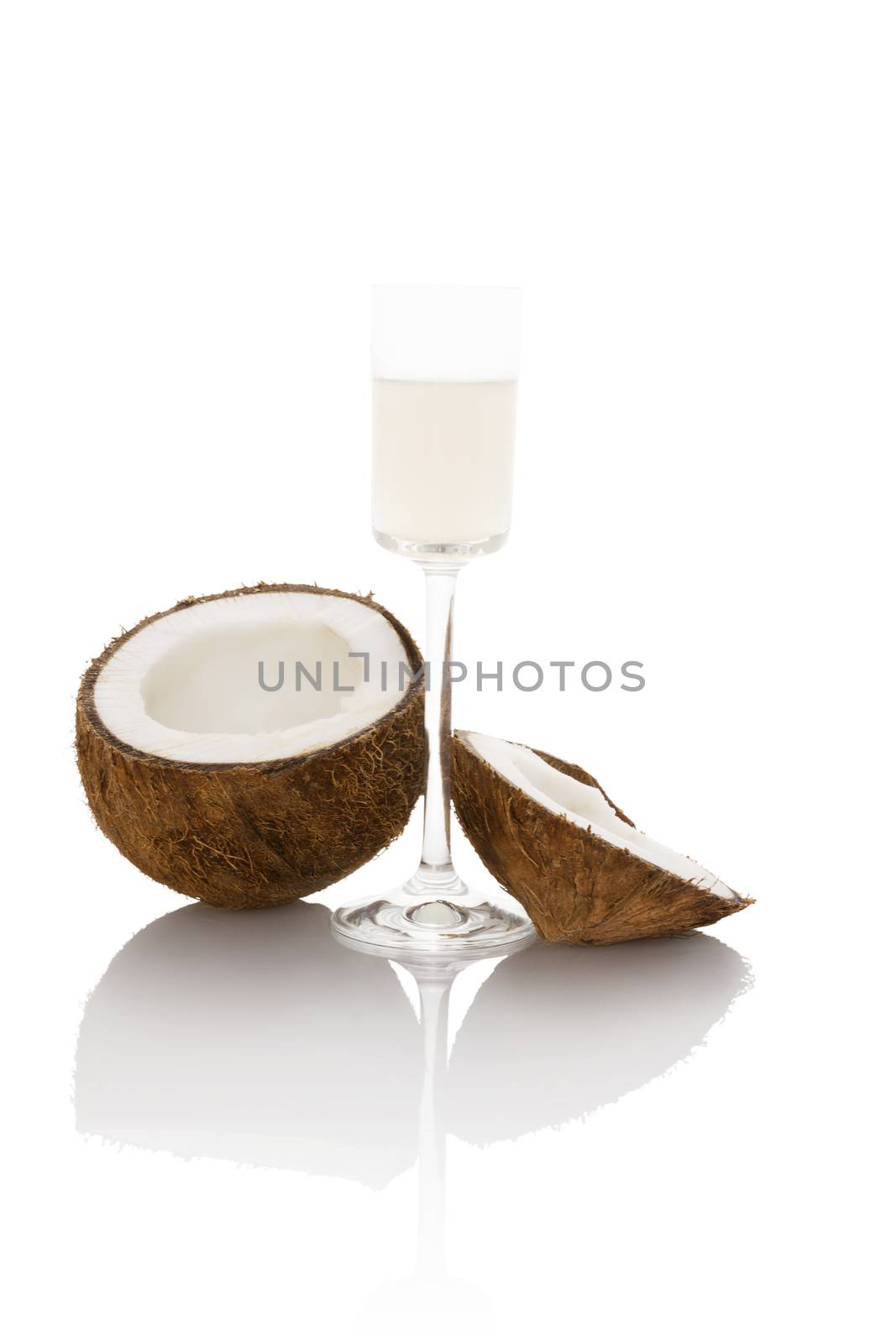 Organic liquid coconut oil in glass with coconut isolated on white background. Healthy eating and cooking.