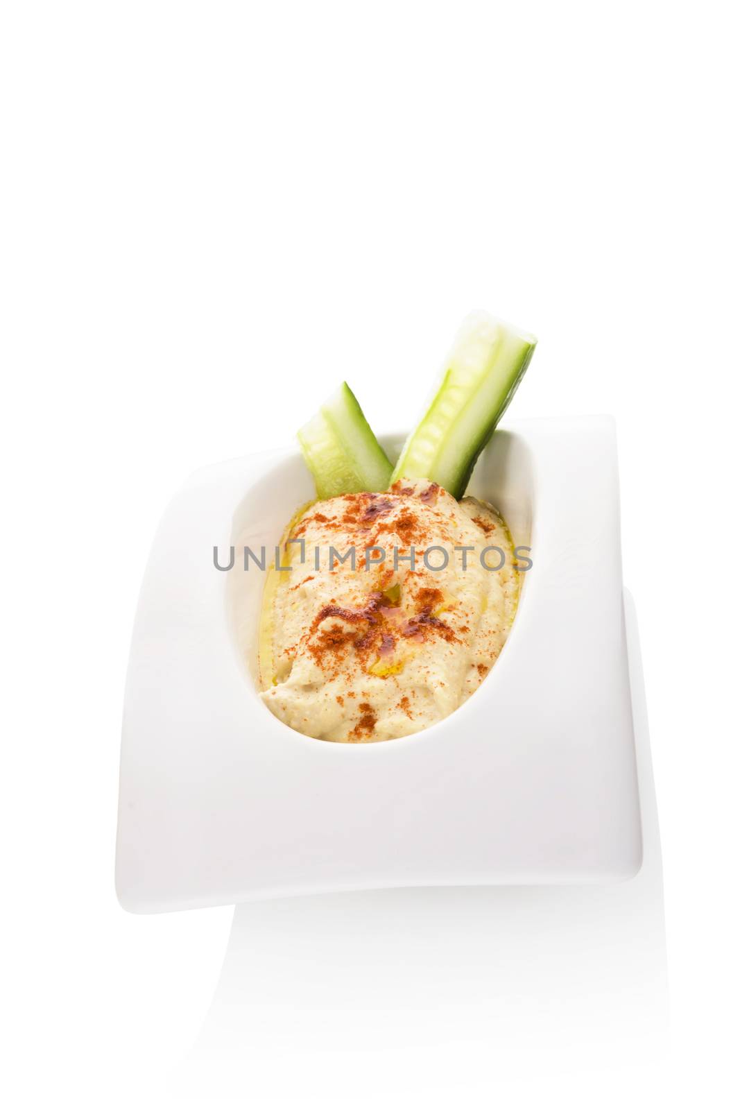 Hummus in white bowl isolated on white background. Minimal contemporary style. Culinary eastern cuisine.