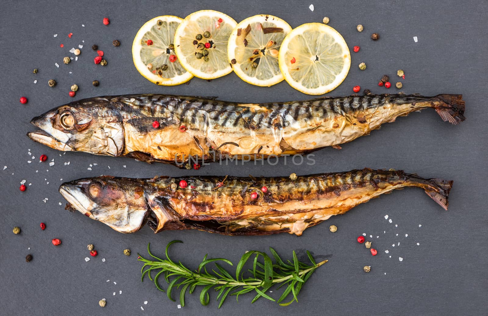 Baked Whole Mackerel Fish with Spice, Lemon and Rosemary on Grey Stone