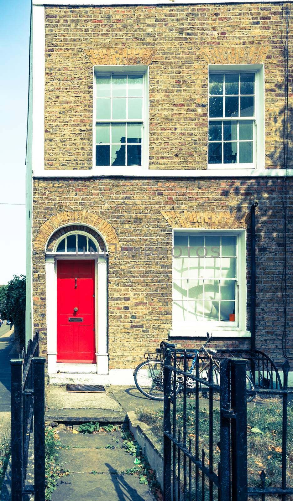 Vintage effect, split East London terrace home with red door.