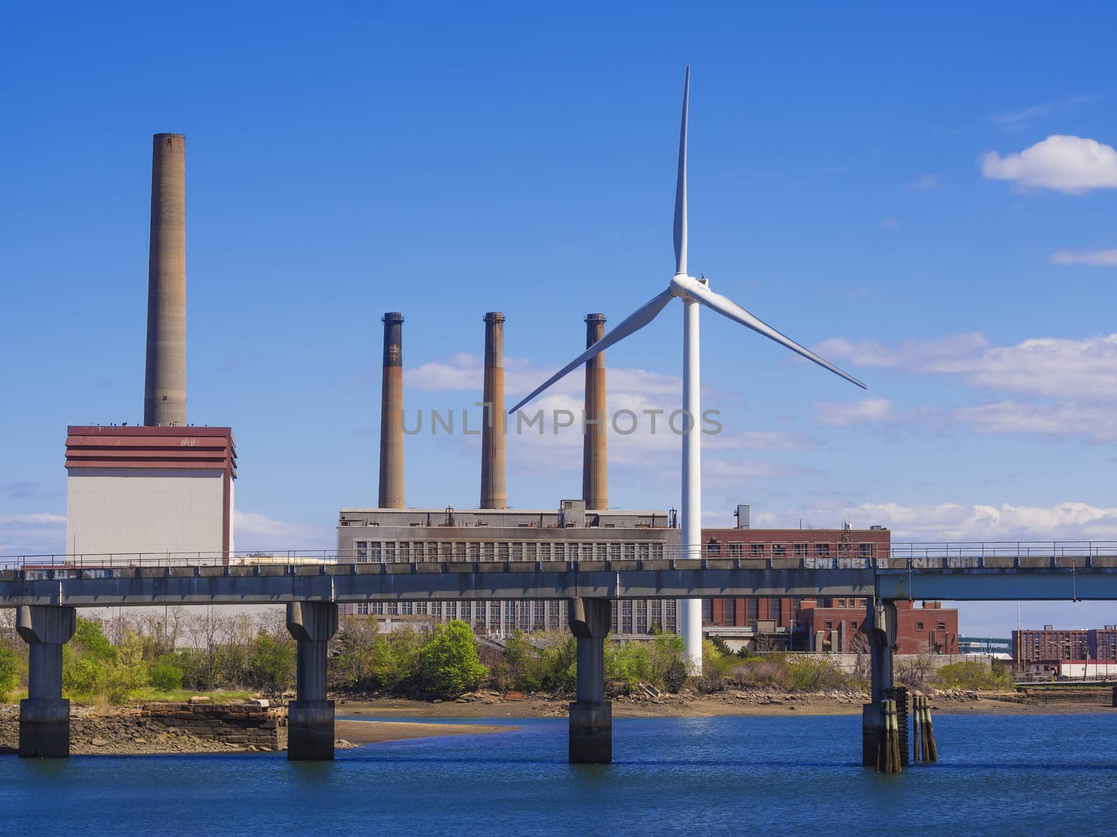 Eco power, wind turbine in the city replacing old style fossil fuel burning plant