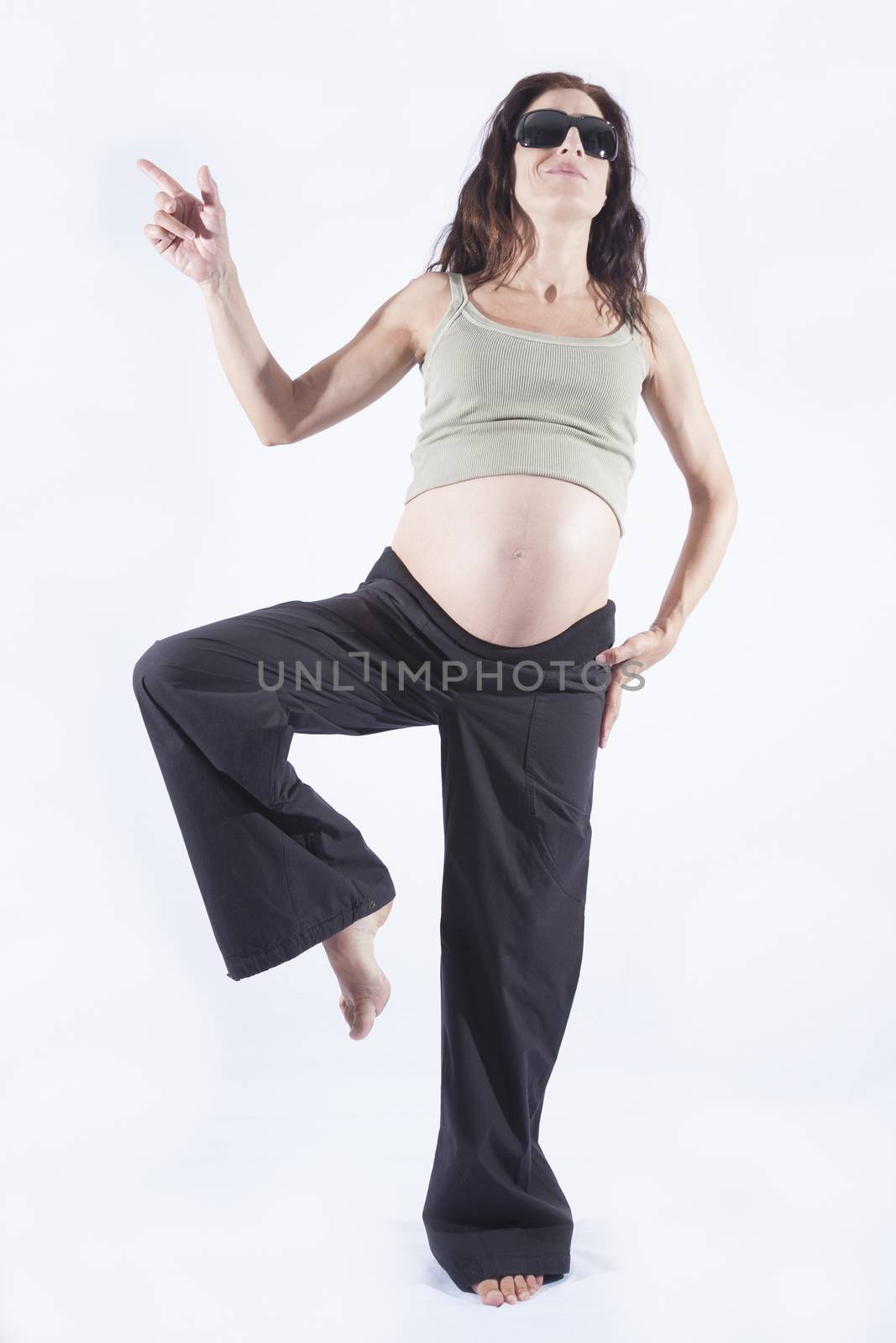 eight month brunette pregnant woman naked paunch black sunglasses smiling standing pointing with finger isolated over white background