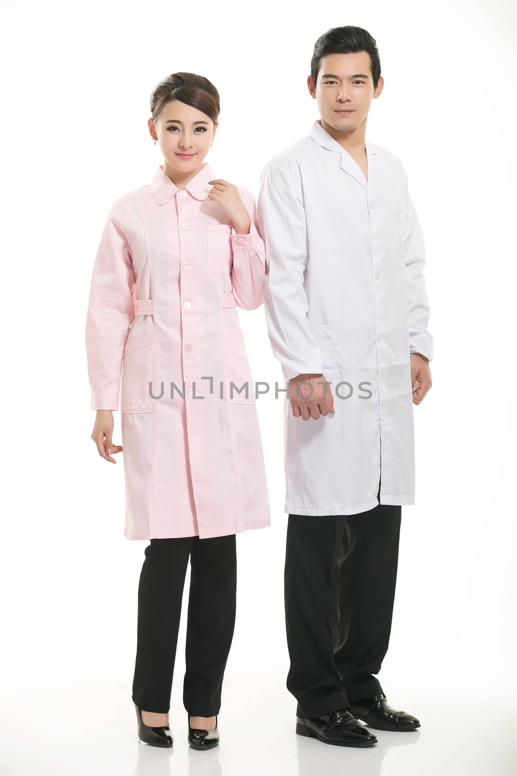 Staff wear coats in front of white background