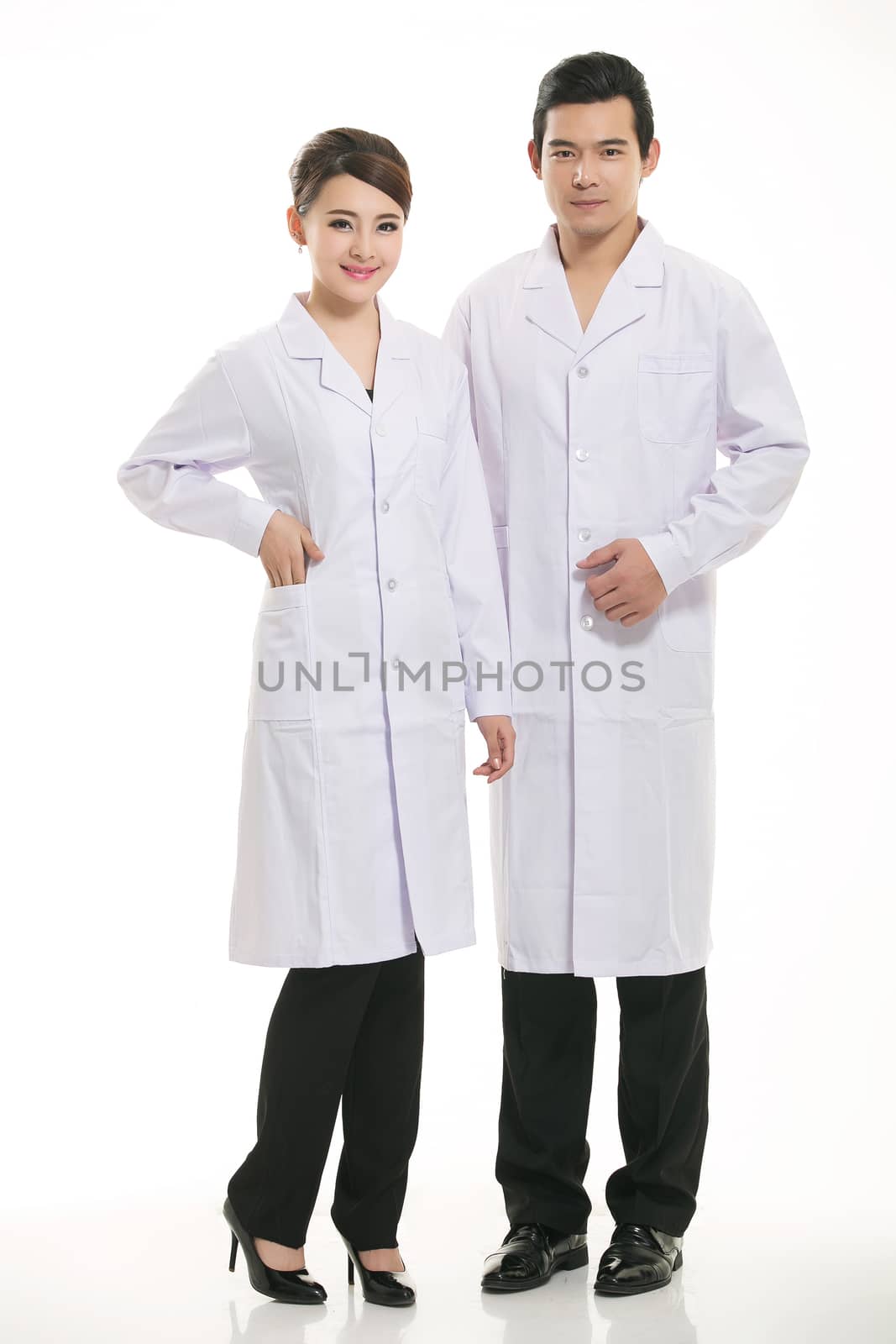 Staff wear coats in front of white background
