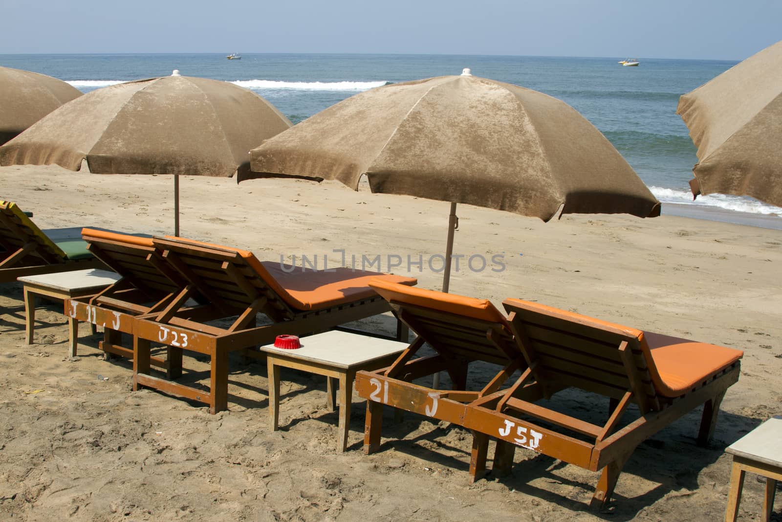 Plank beds and sunshades on a beach. India Goa by mcherevan