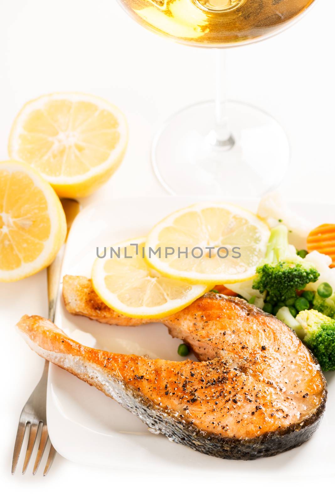 Grilled salmon and vegetables on plate with wine by Nanisimova