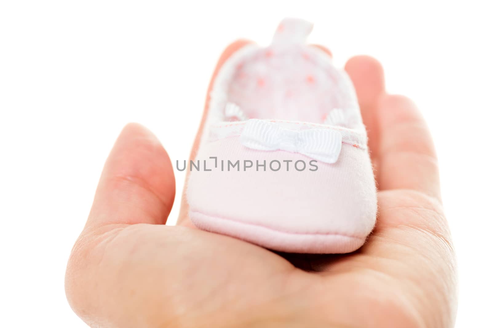 Close up pink baby shoes on hand horizontal by Nanisimova