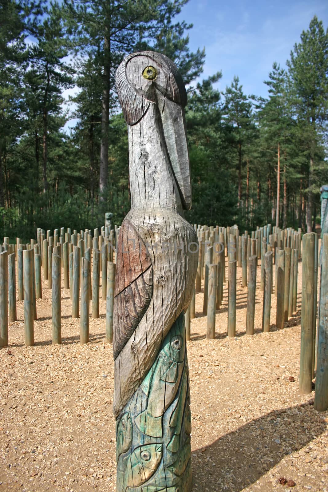 A totem pole with a bird and fishes in the forest