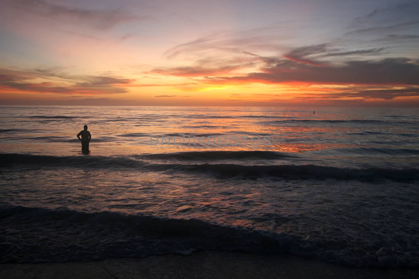 A stunning sunset over the ocean with person gazing