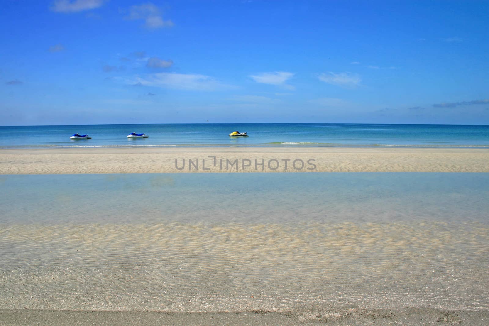 3 jet skis on the ocean near the beach