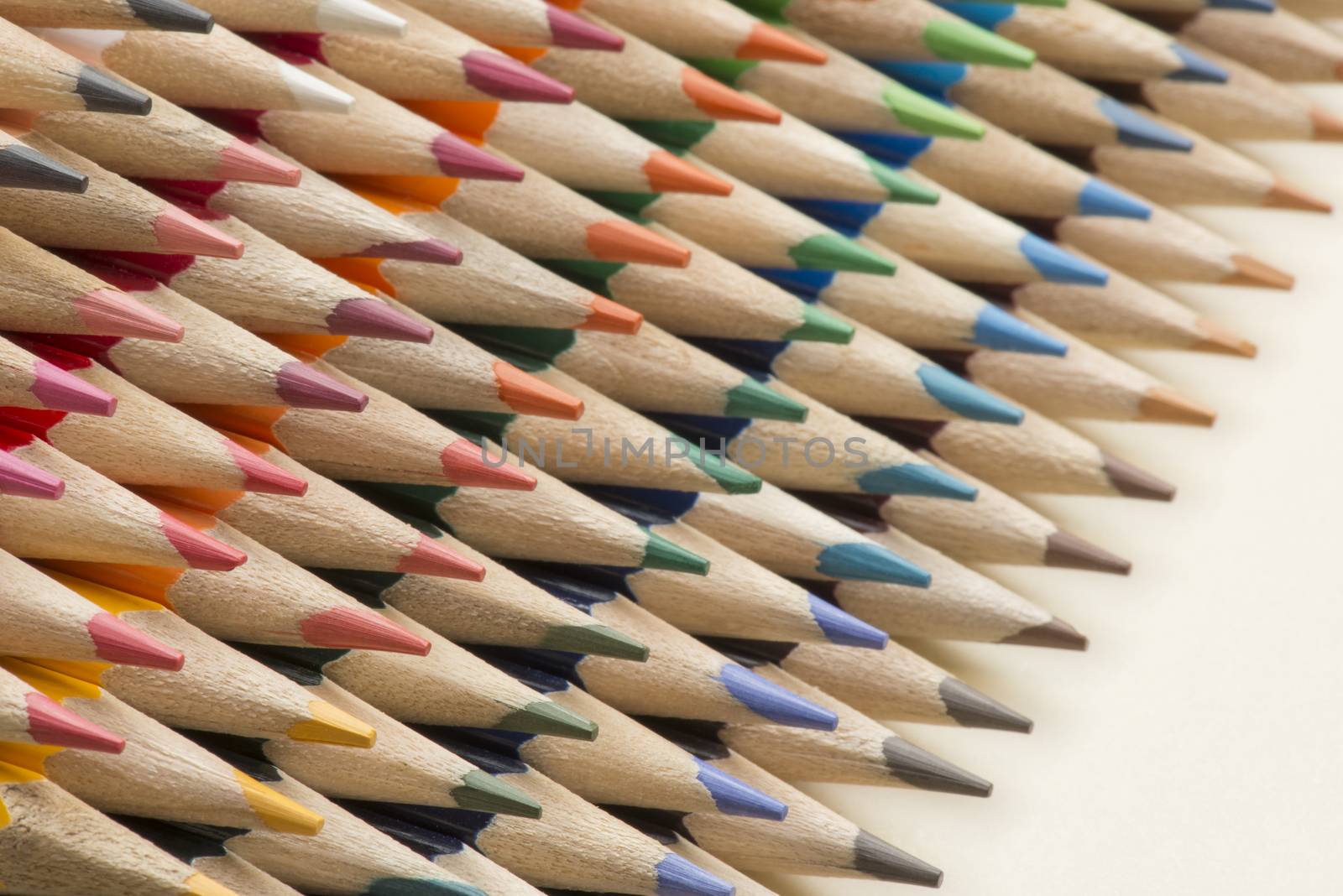 Abstract composition of a set wooden colour pencils against a white background