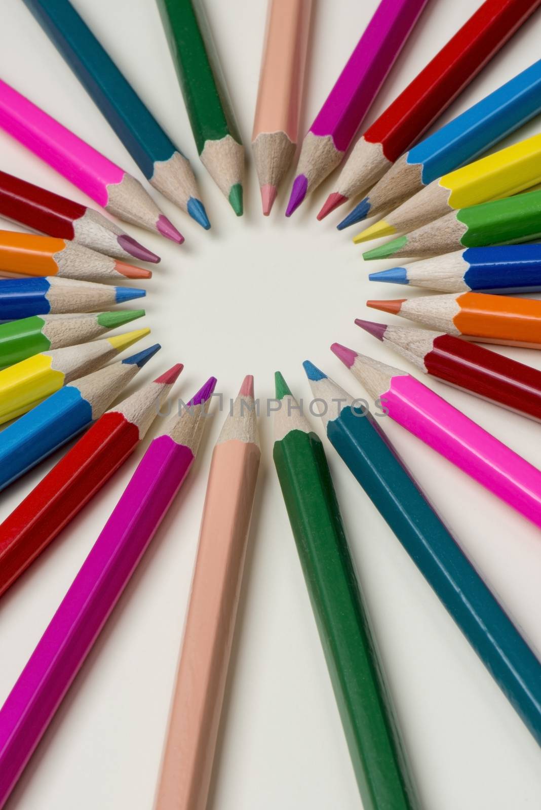 Abstract composition of a set wooden colour pencils against a white background