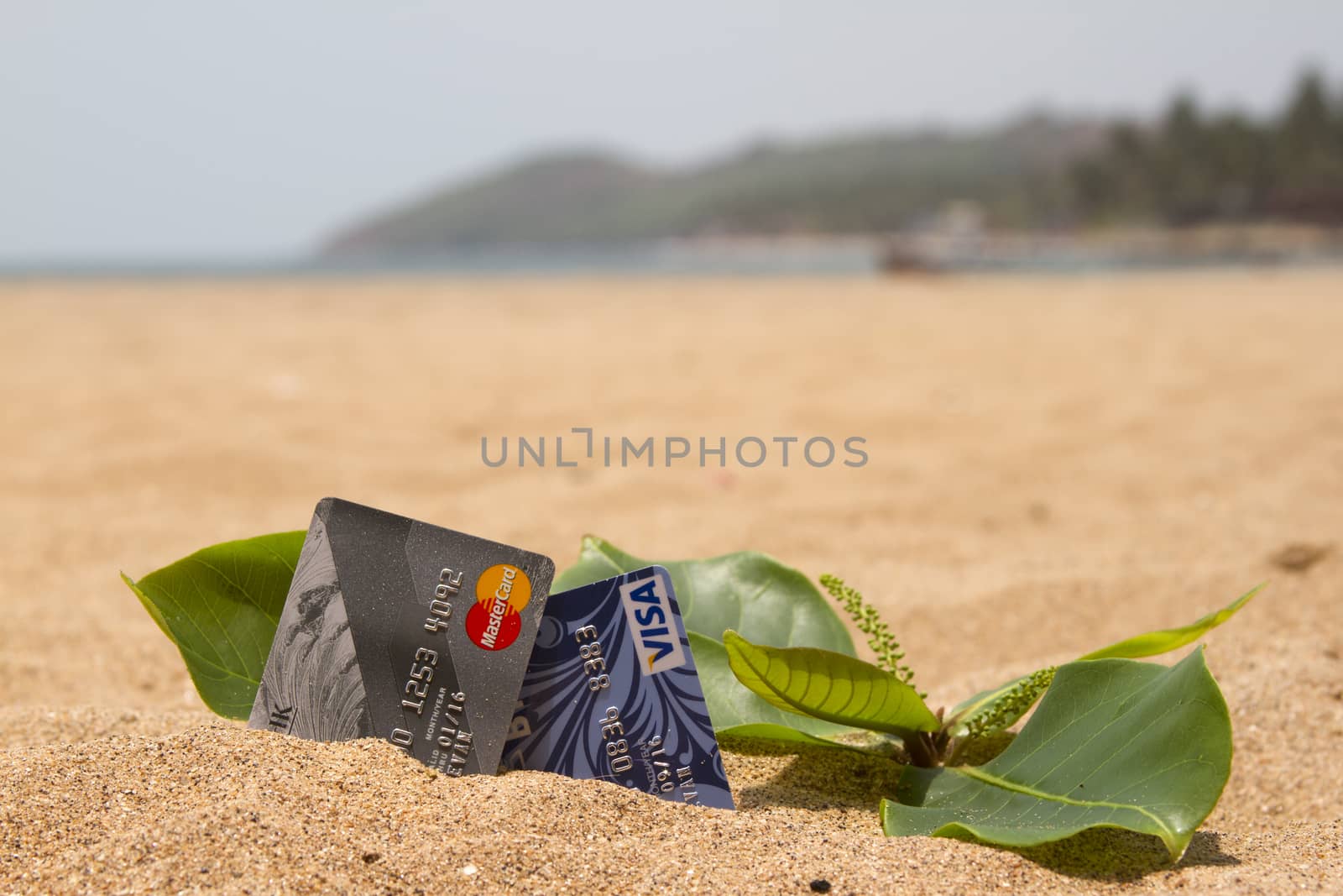 Credit card lying on the sand beach. India Goa by mcherevan