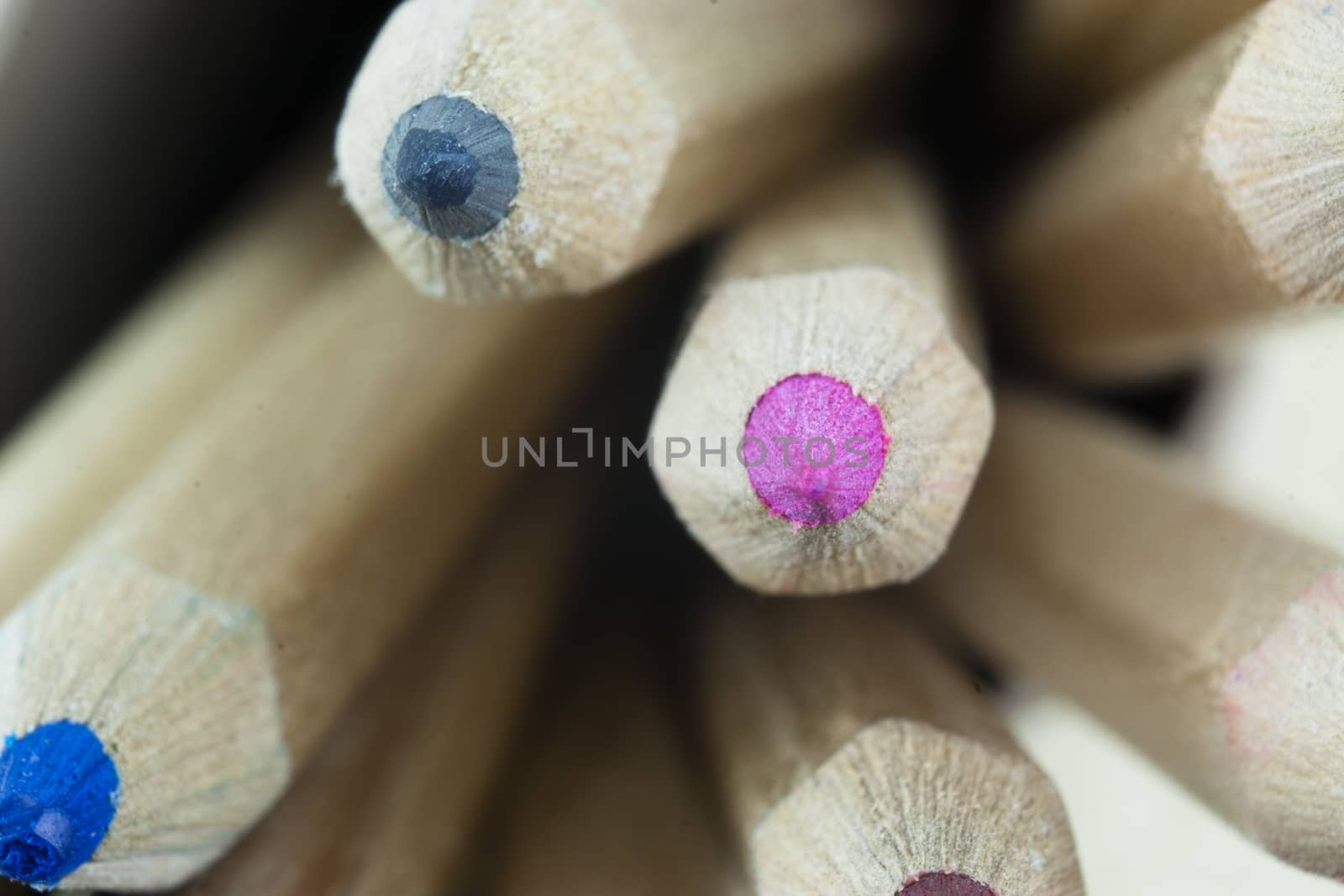 Close f of coloured pencils against a wooden background