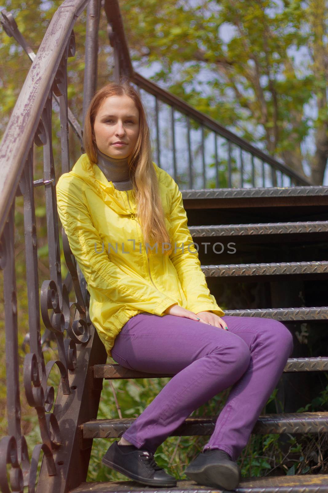 teenage girl sitting alone on the stairs.