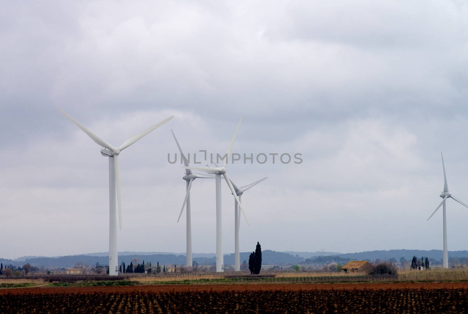 White Electrical Power Generating Wind Turbines on Spring Cloudy Skies background, France