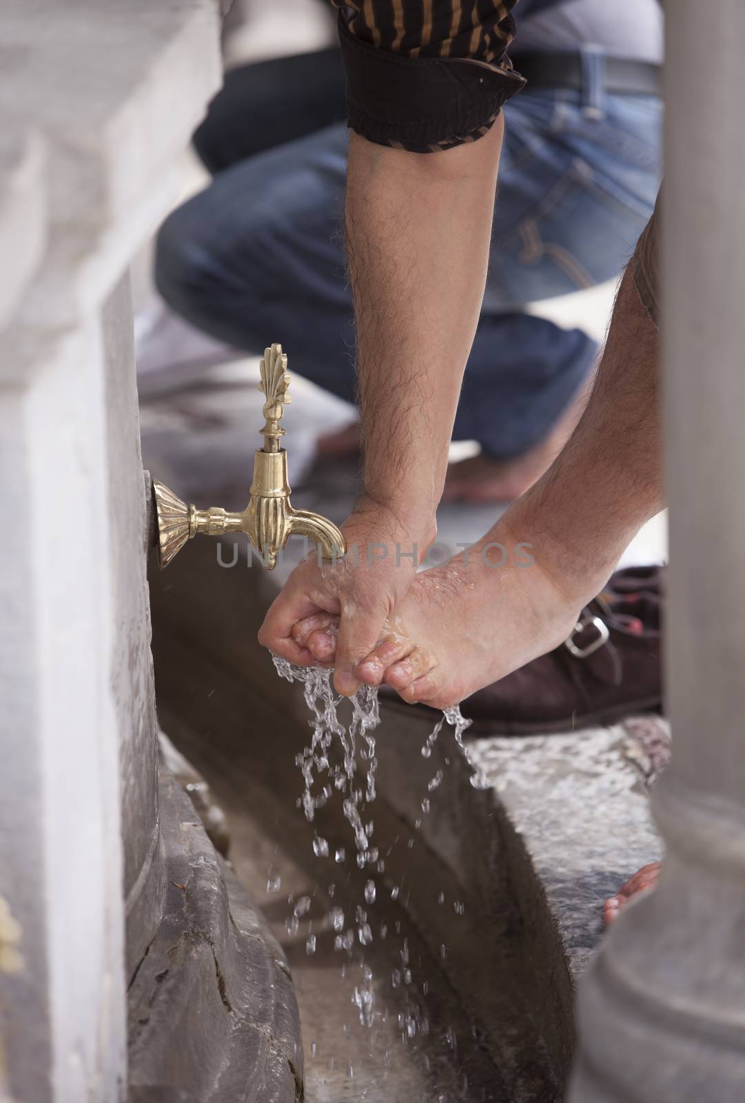 Muslim man in Turkey washing his feet in public fountain