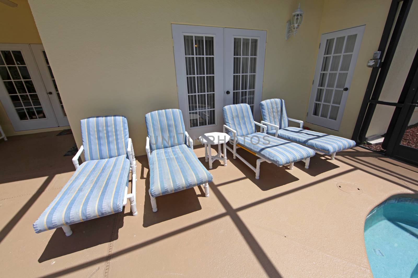 Four pool loungers in a pool area