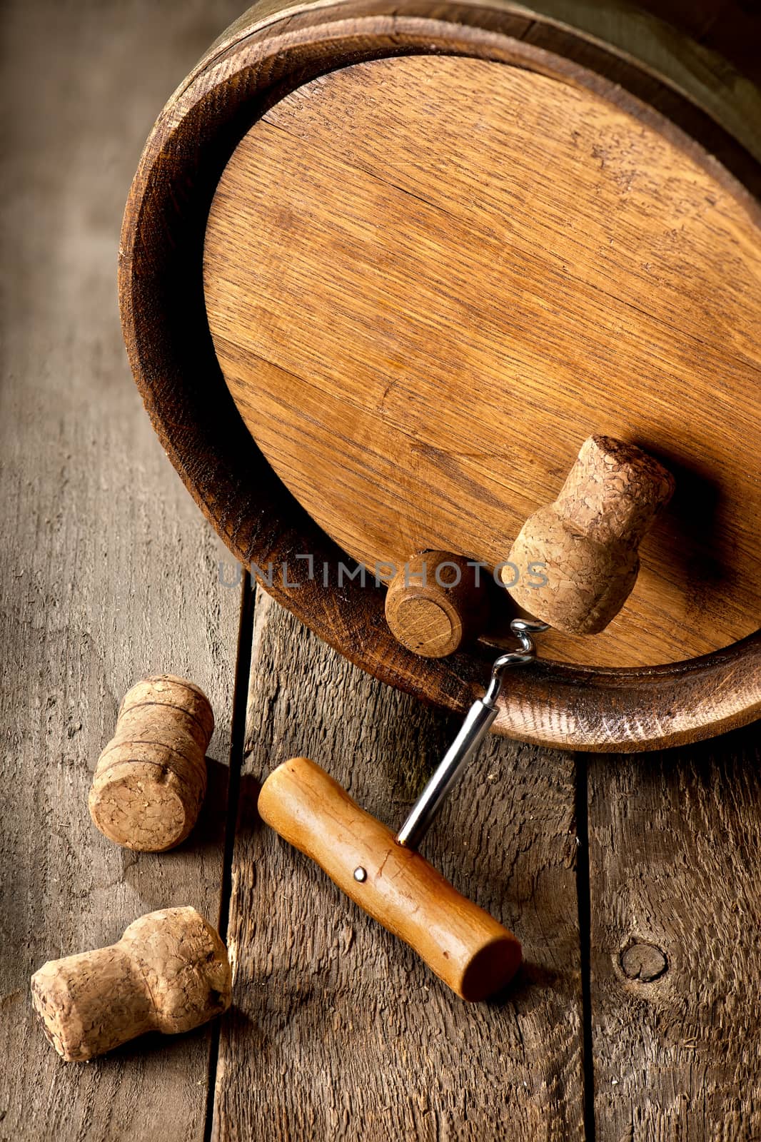 Cask with corks and corkscrew on a wooden table