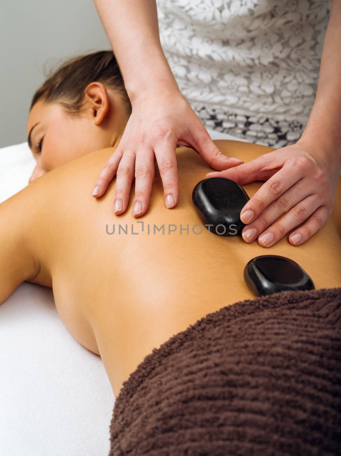 Massage therapist placing the hot stones by sumners