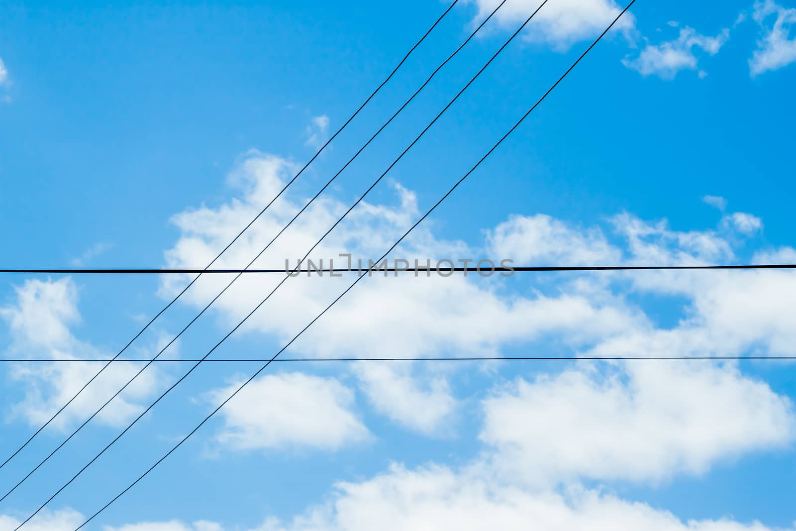 crossing wires on blue cloudy sky background 