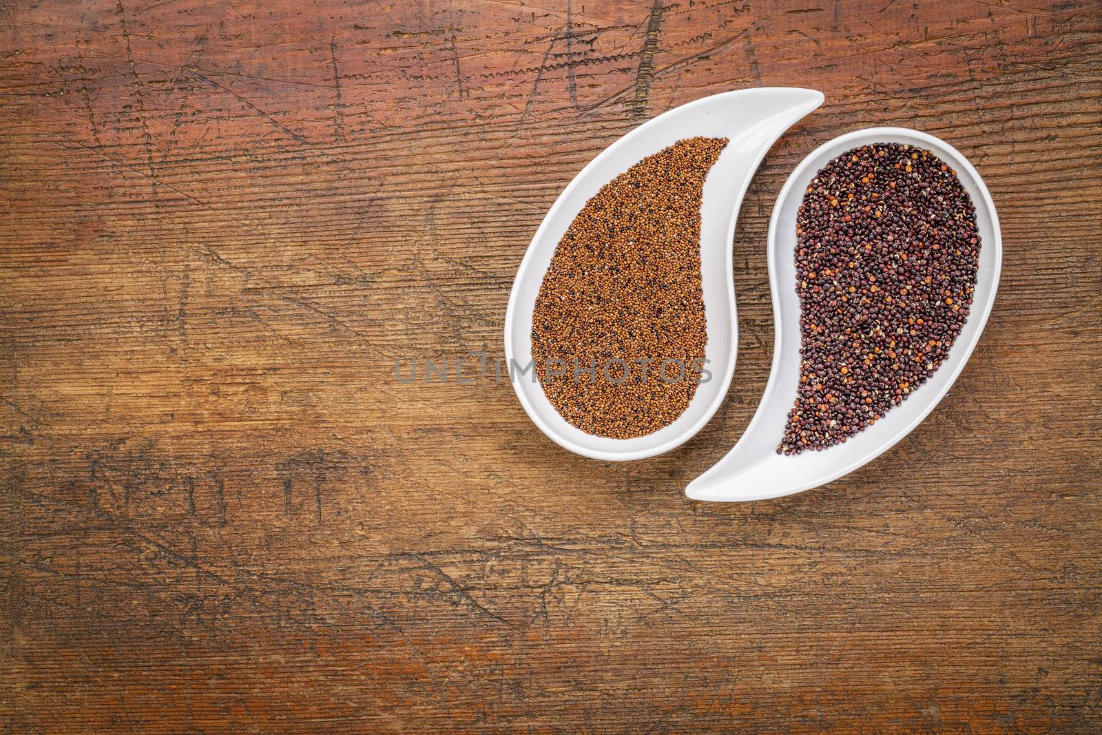 kaniwa and black quinoa  gluten free grains on on teardrop shaped bowls against rustic wood with a copy space