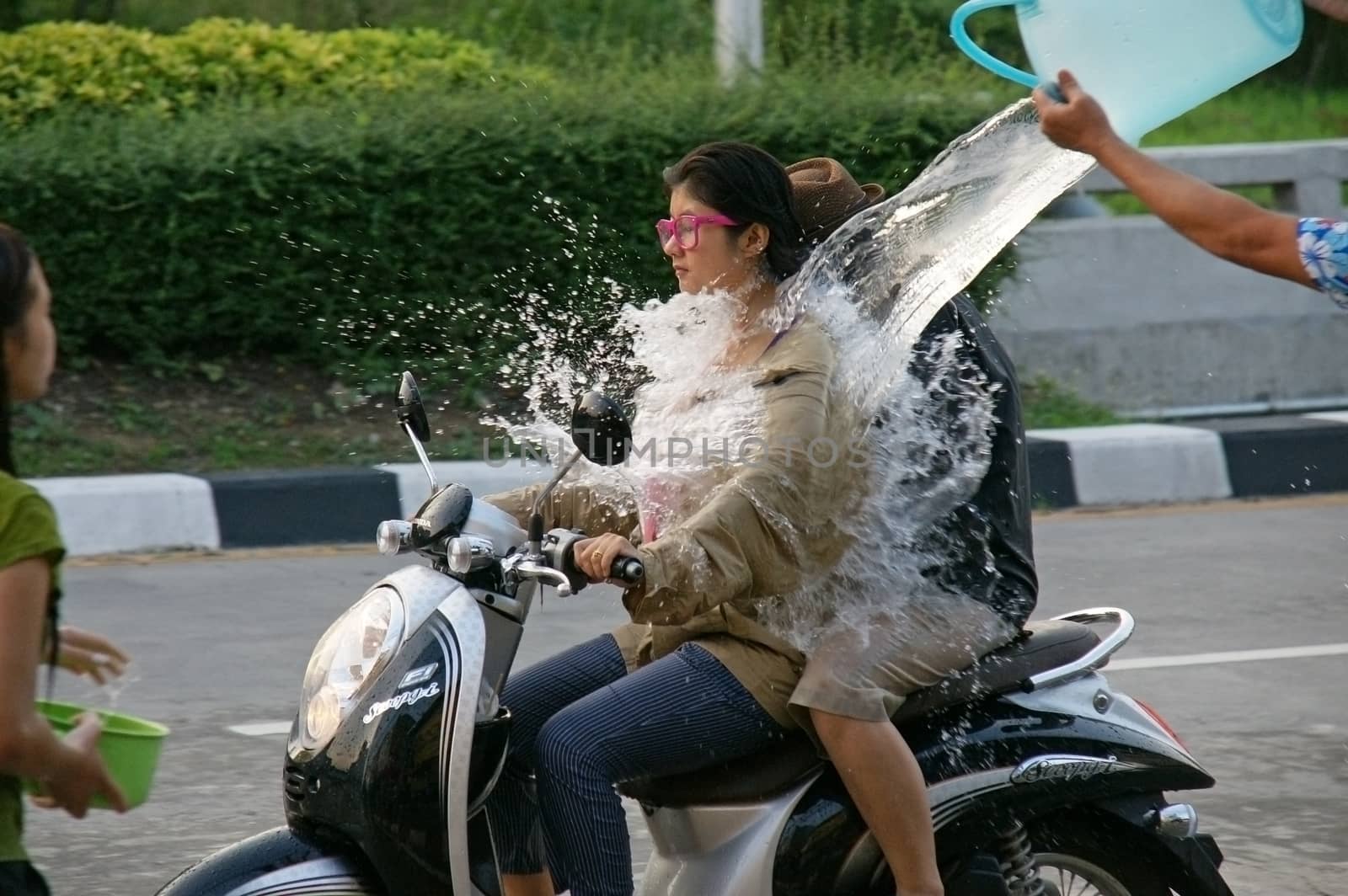 CHIANGMAI,THAILAND-APRIL 14, 2011:Unidentified tourist with motorcycle in a water fight festival or Songkran Festival (Thai New Year), on April 14, 2011 in Chiangmai, Thailand.