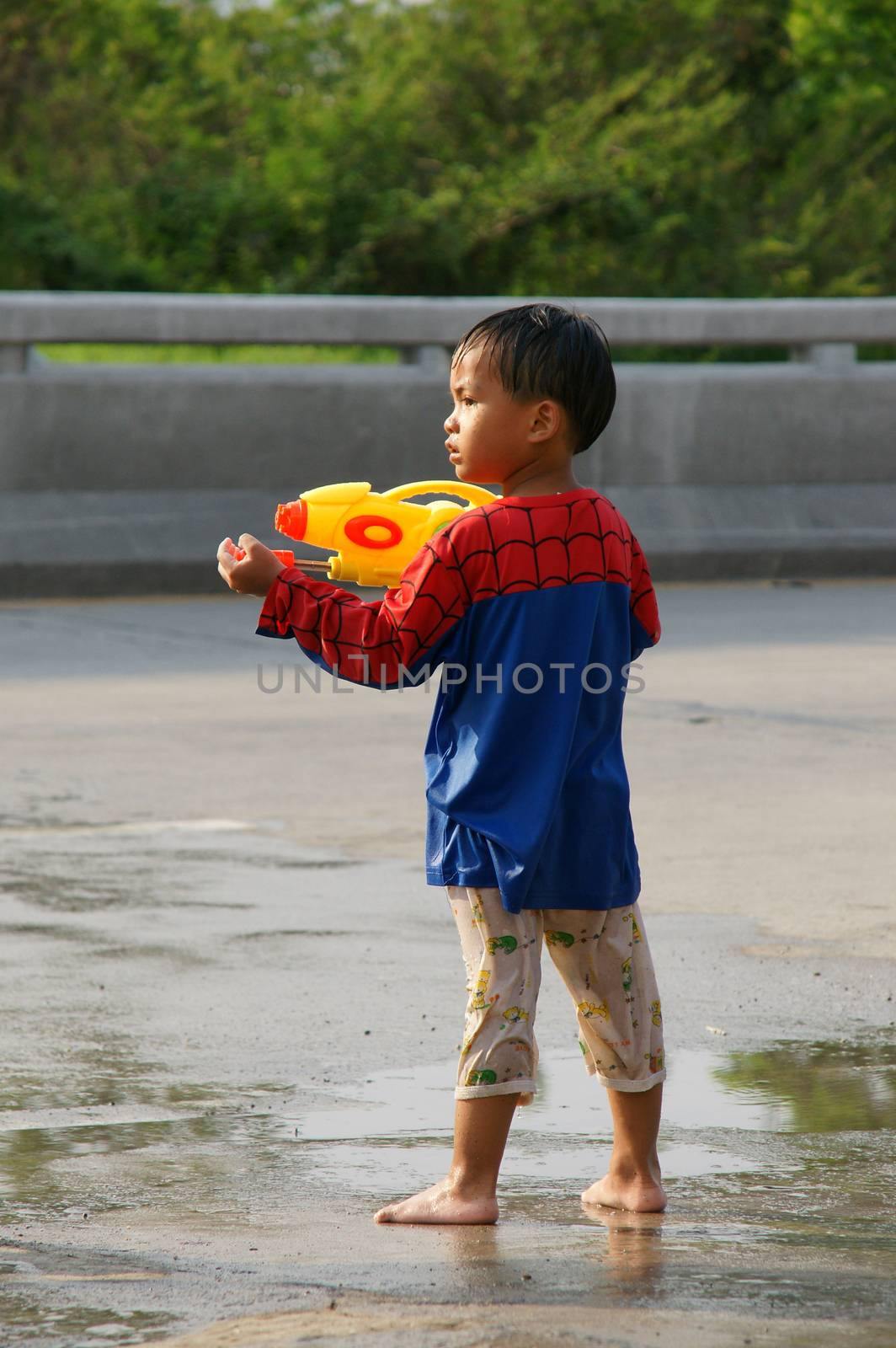 The boy with water pressure gun in a water fight festival by mranucha