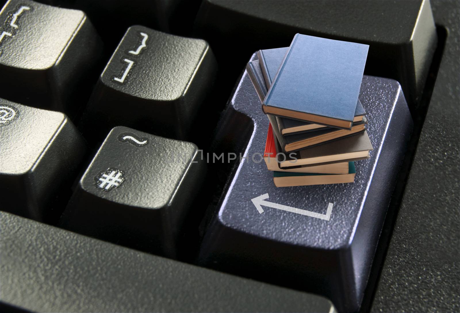 Stack of books on top of a computer enter key