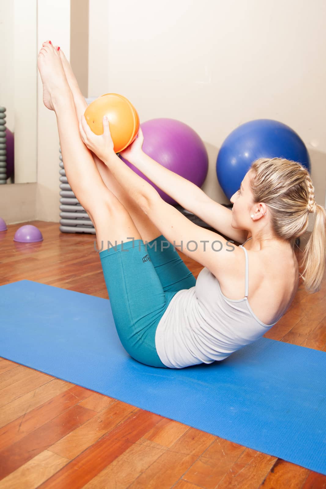 Woman stretching in yoga with a ball by ifilms